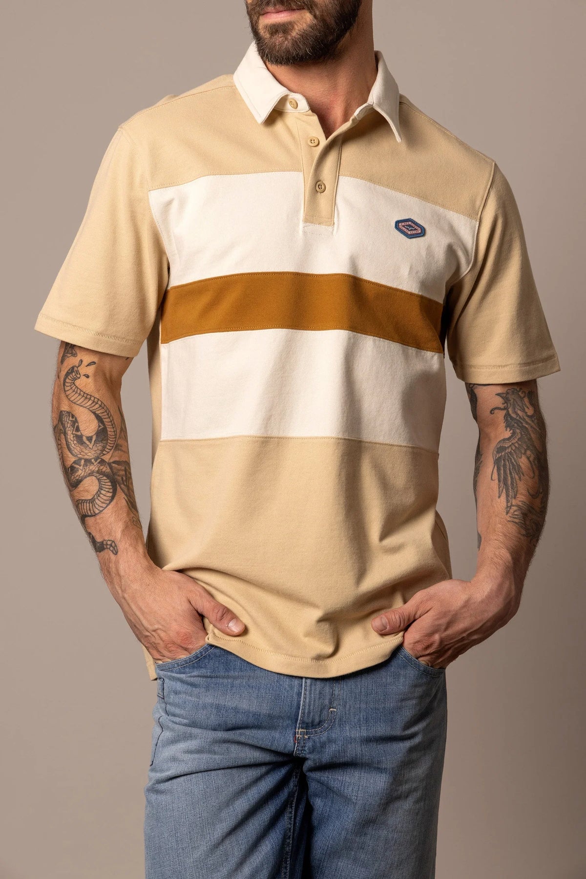 Kimes Ranch 1874 Polo in Tan with a white chest stripe and a mustard stripe with a small logo