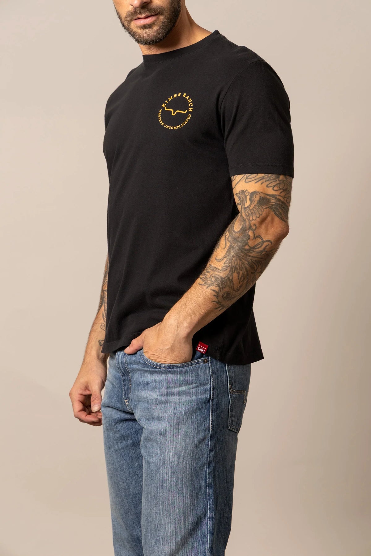 Kimes Ranch 1956, side view, Black short sleeve shirt with chest logo and red hem tag
