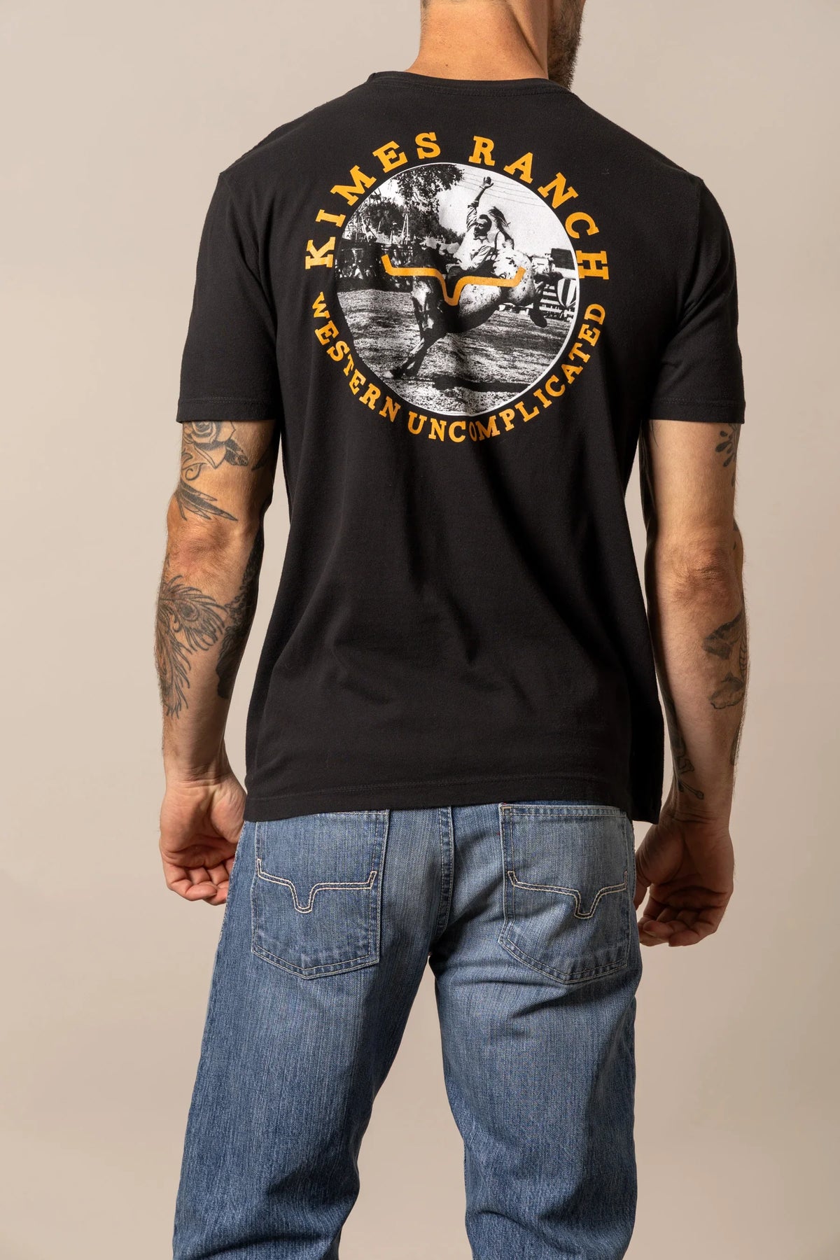 Kimes Ranch 1956, back view, Black shirt with a circular back graphic of a cowboy on a bucking horse
