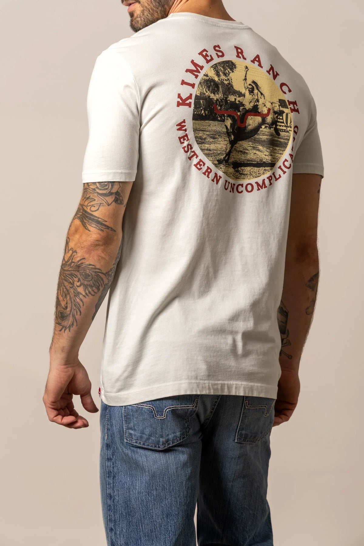 Kimes Ranch 1956 shirt in Natural, back view, with a back graphic of a cowboy on a bucking horse