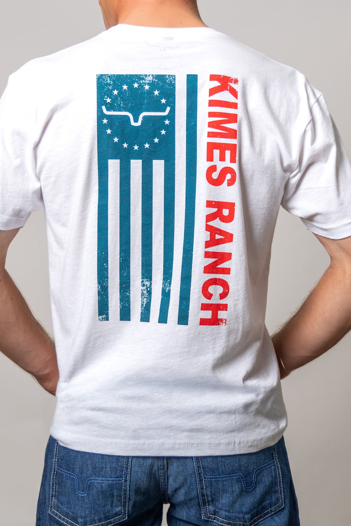 Kimes Ranch 76 shirt in White, back view, with a distressed blue flag graphic and red KIMES RANCH text on the back