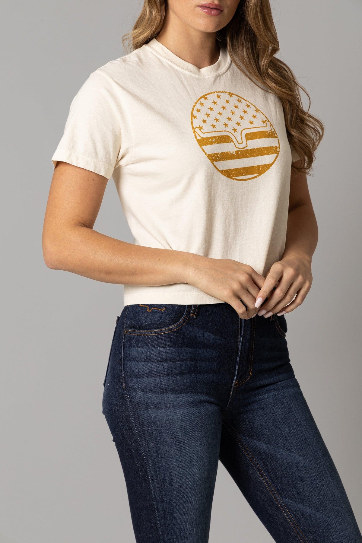 Kimes Ranch Ladies American Bullseye Crop shirt in Ivory with a gold graphic of the Kimes Ranch logo filled with stars