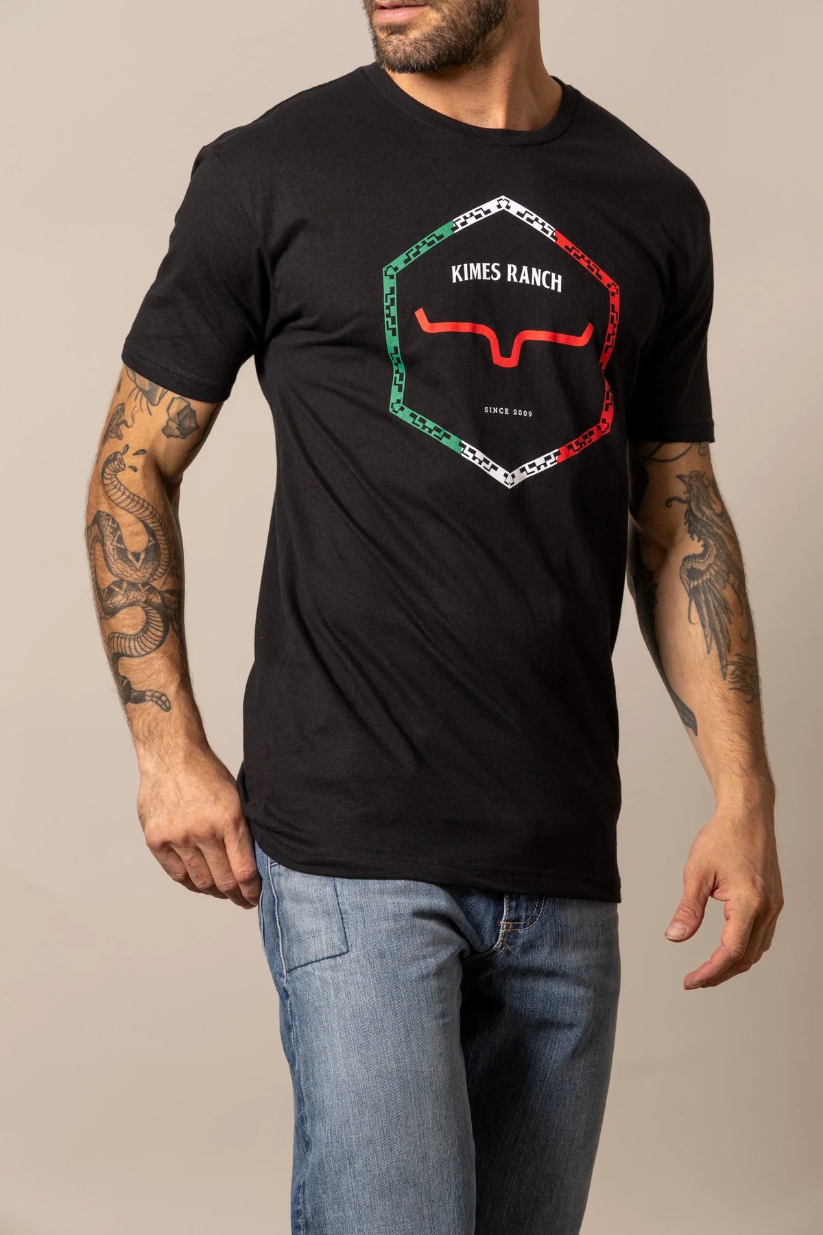 Kimes Ranch Baja Diamond Black shirt with a hexagonal logo featuring red steer horns and green and white borders
