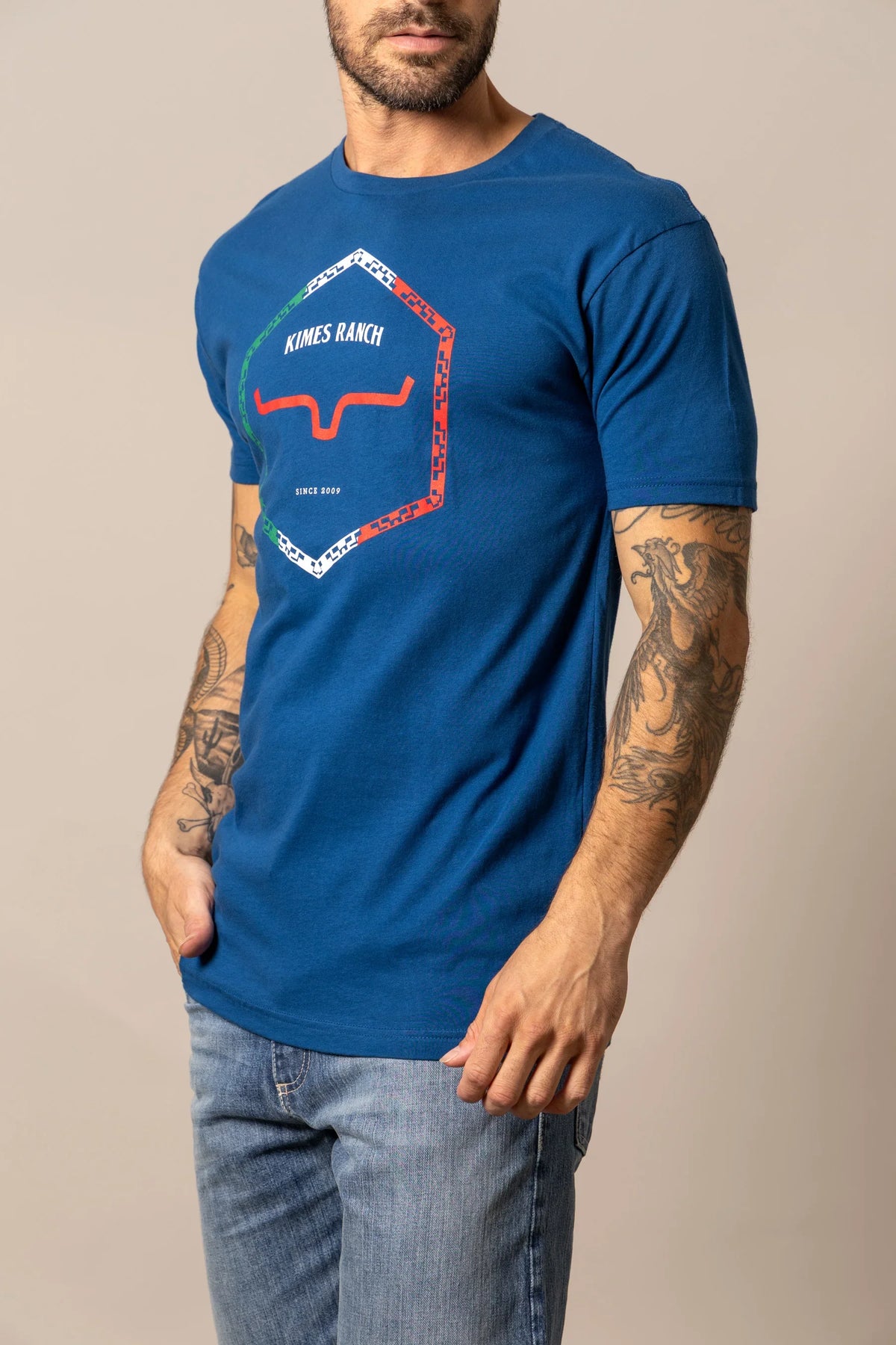 Kimes Ranch Baja Diamond shirt in blue with a hexagonal logo and red steer mark
