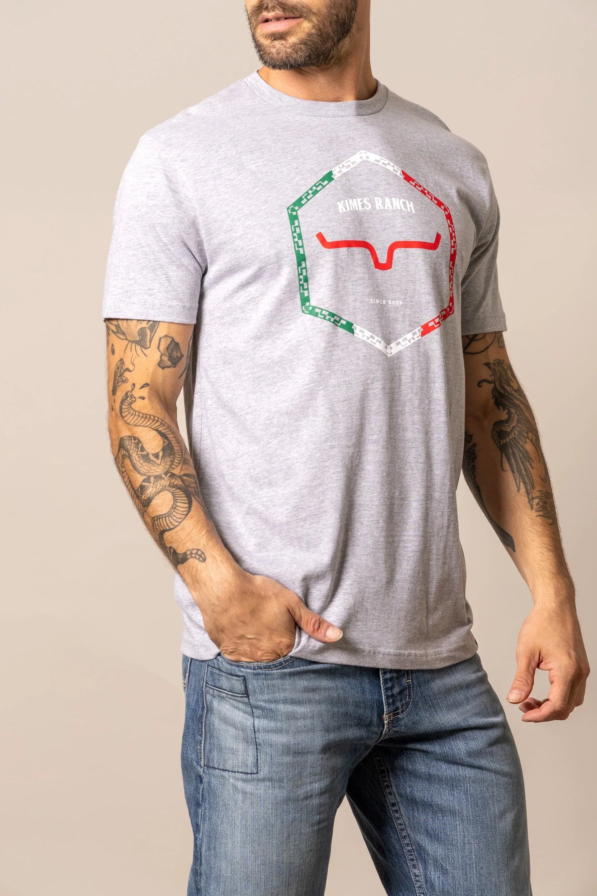 Kimes Ranch Baja Diamond short sleeve shirt in grey with a hexagonal logo featuring red and green accents