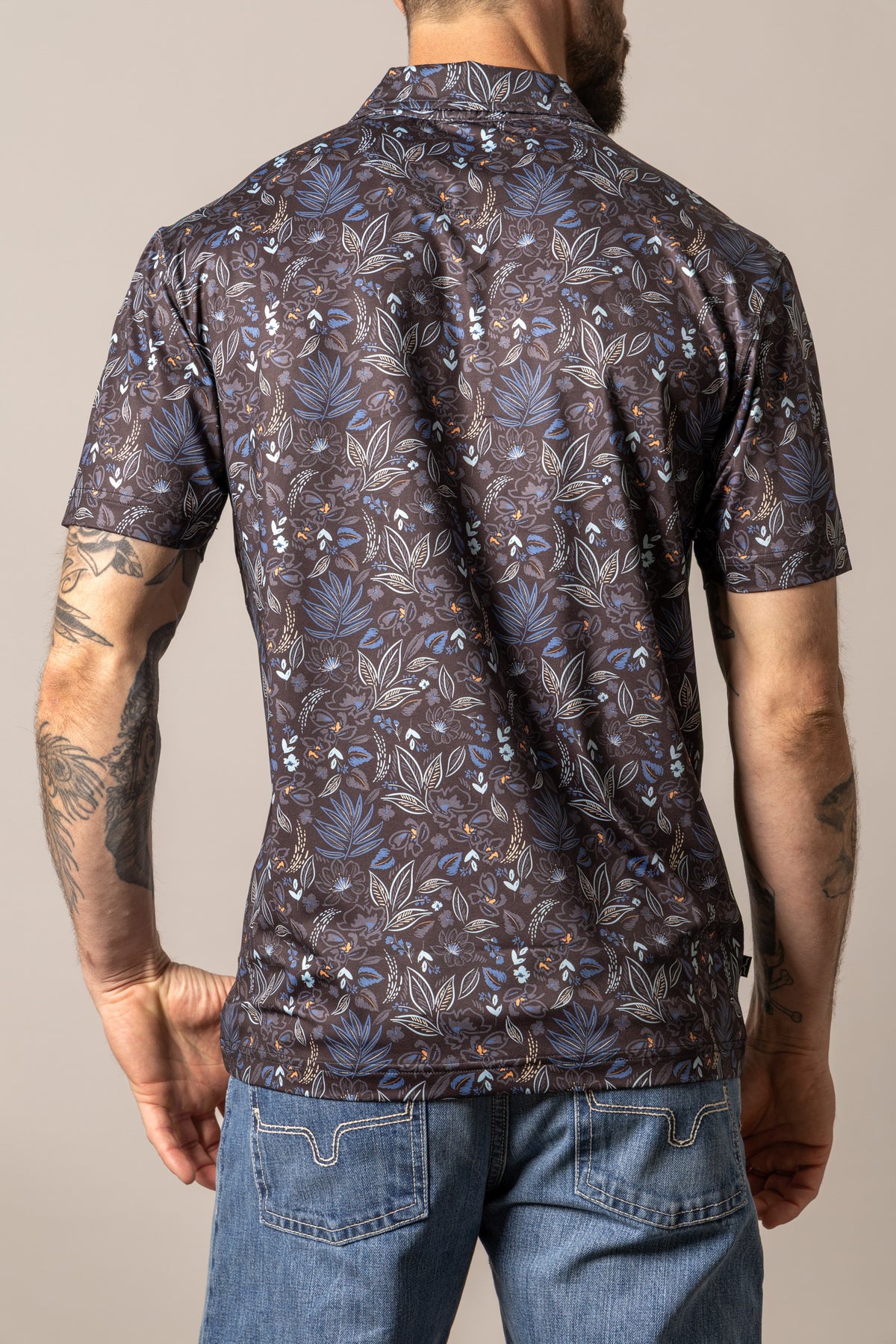 Kimes Ranch Bartram polo shirt in Black, back view, with a blue and white floral print pattern on the back