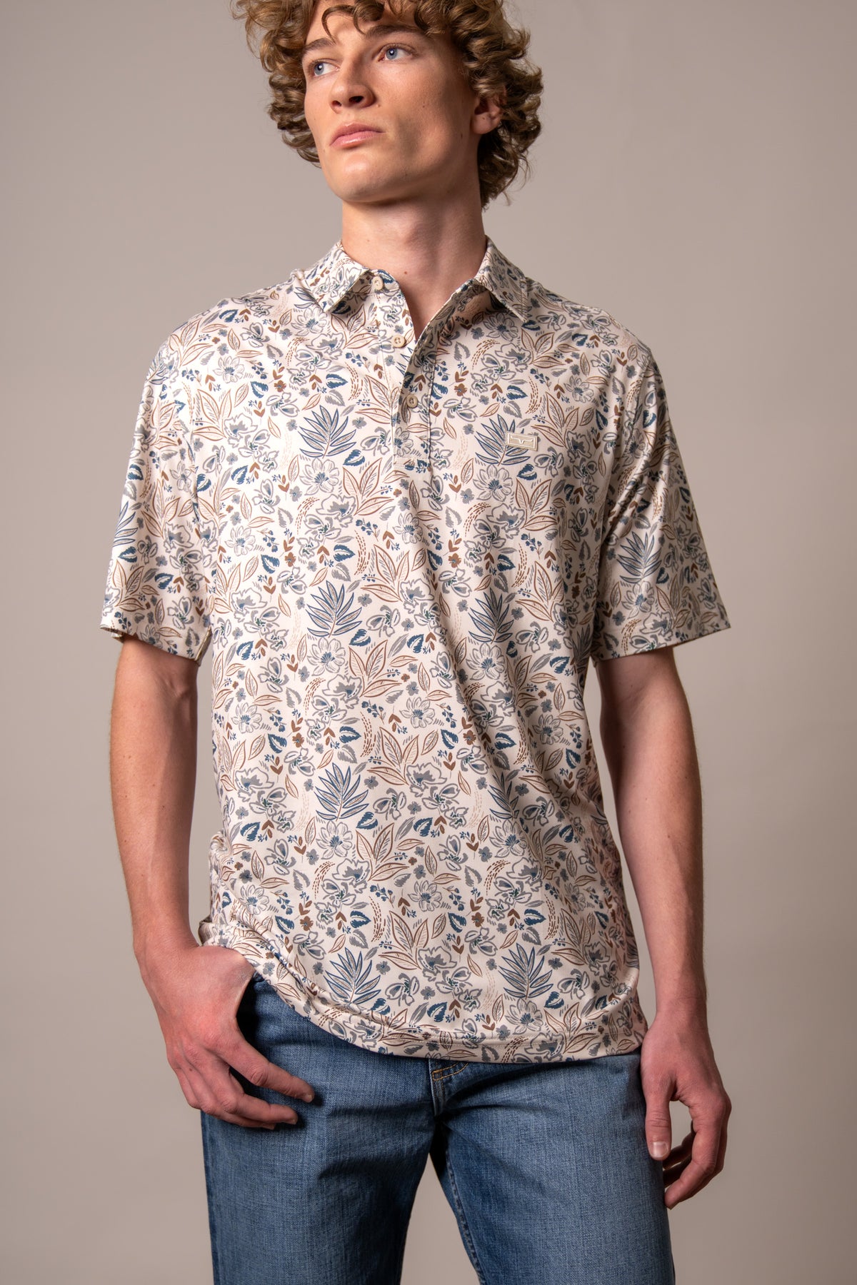 Kimes Ranch Bartram polo shirt in Stone with a blue and brown floral print and a small logo patch on the chest