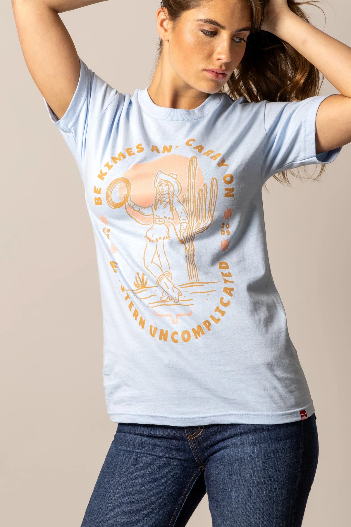 Kimes Ranch Be Kimes shirt in Baby Blue with a graphic of a woman in a cowboy hat and cactus with the text BE KIMES