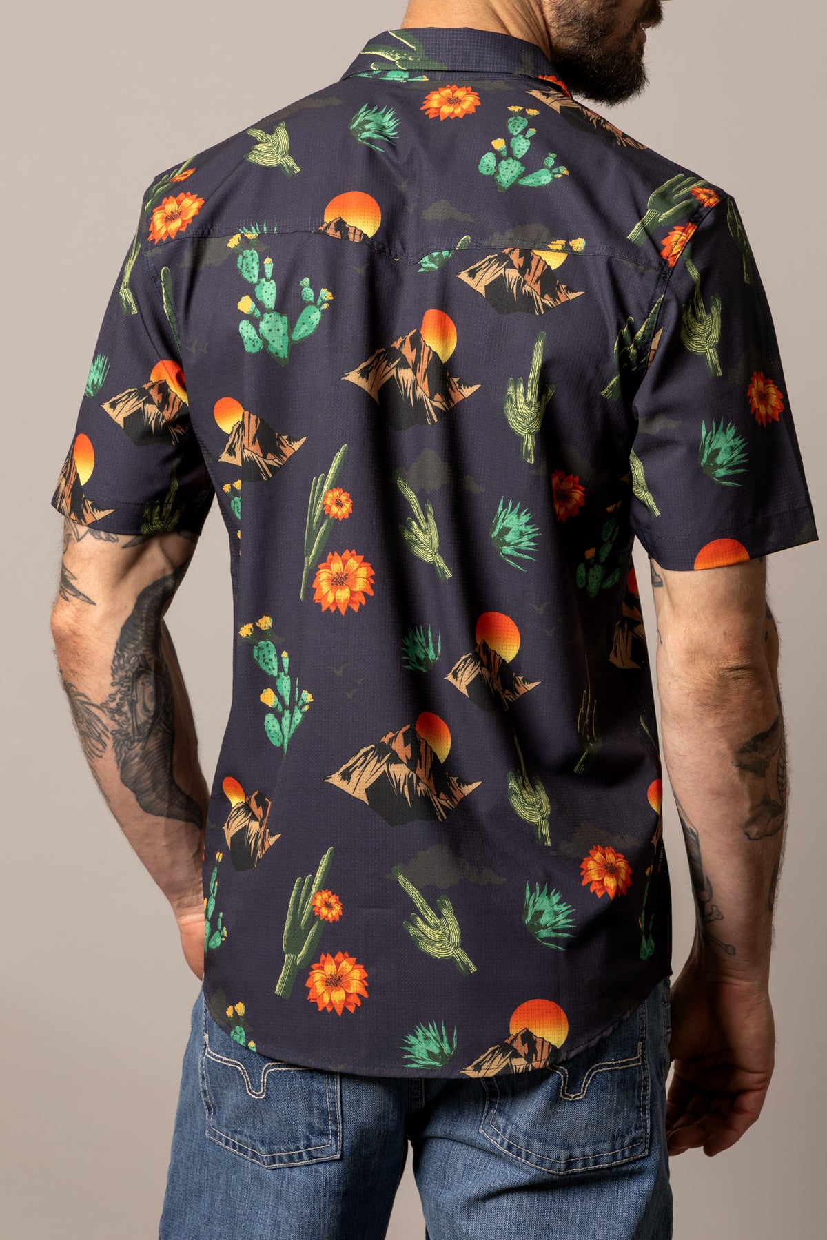Kimes Ranch Berry dress shirt in Black, back view, with a desert print of cacti, mountains, and suns