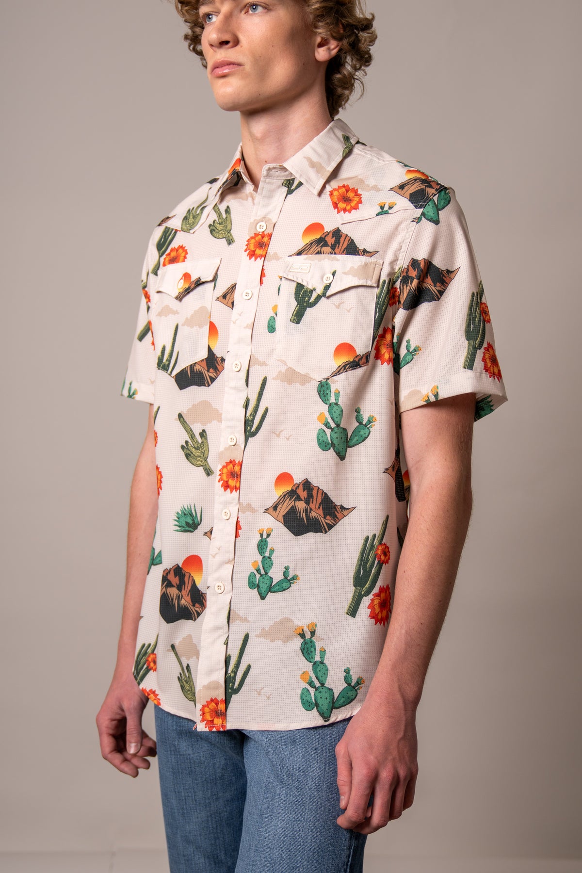 Kimes Ranch Berry short sleeve dress shirt in Natural with a desert print of cacti, mountains, and sunsets