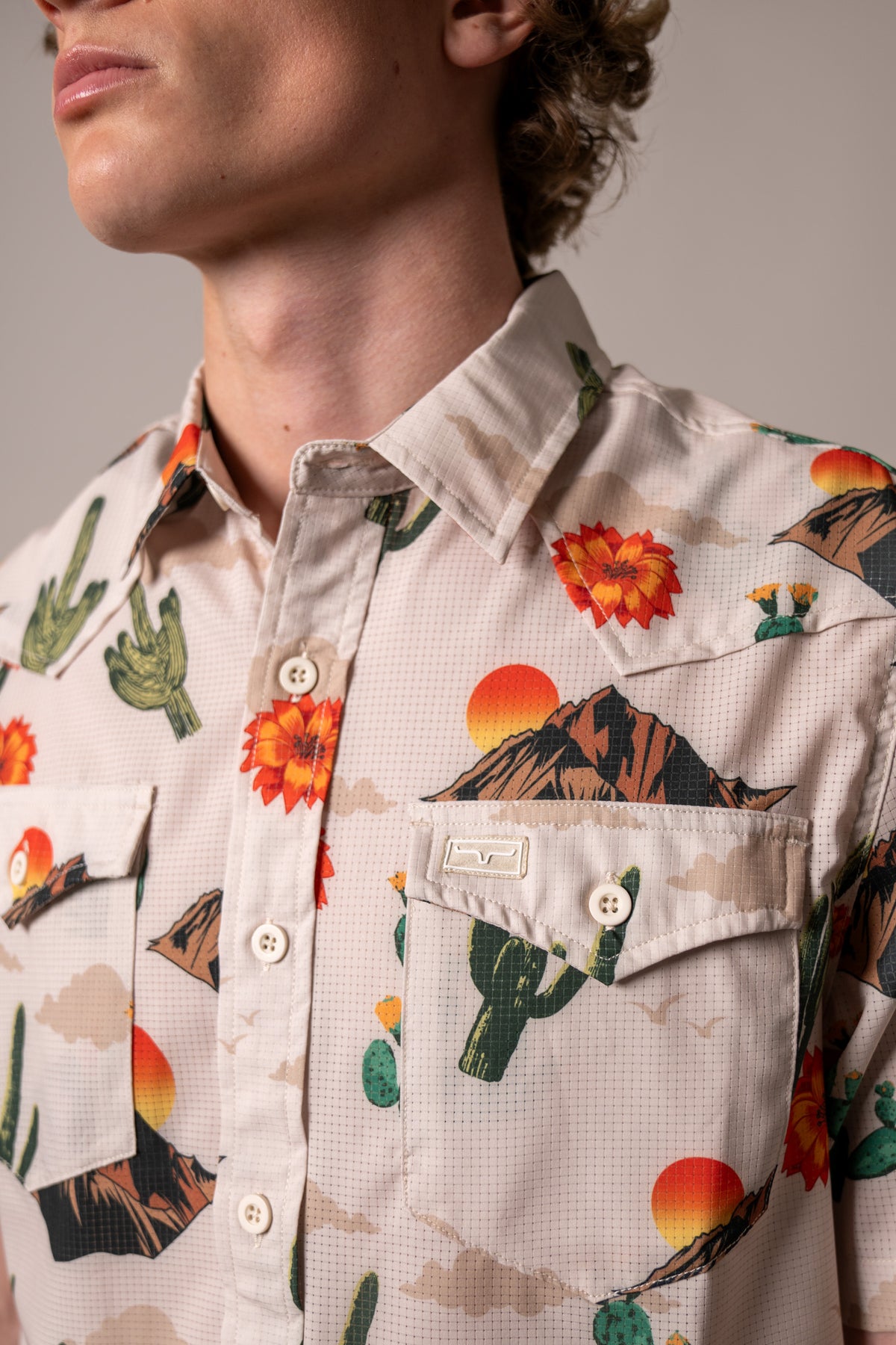 Kimes Ranch Berry dress shirt in Natural, close-up, with a desert print of cacti, mountains, and sunsets