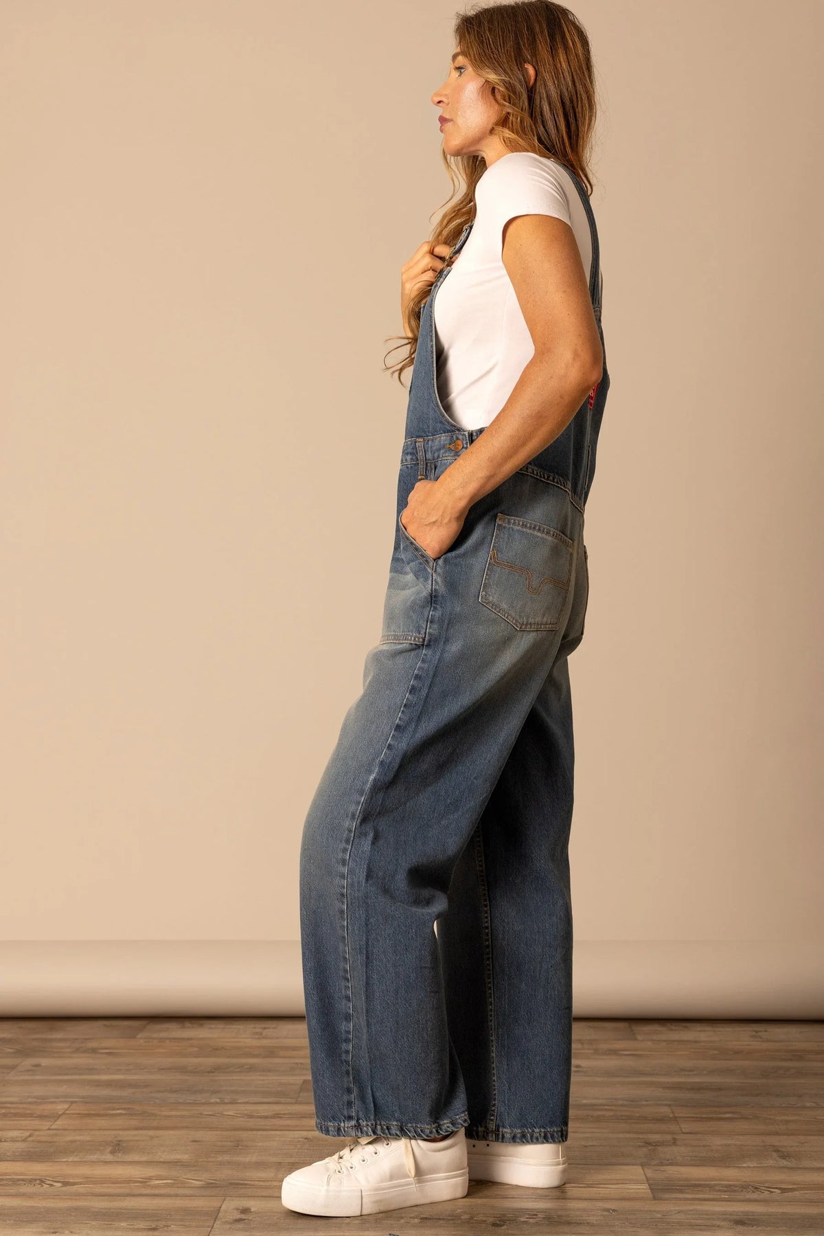 Kimes Ranch Billy Overalls in Dark Wash, side view, with wide leg silhouette and front patch pockets