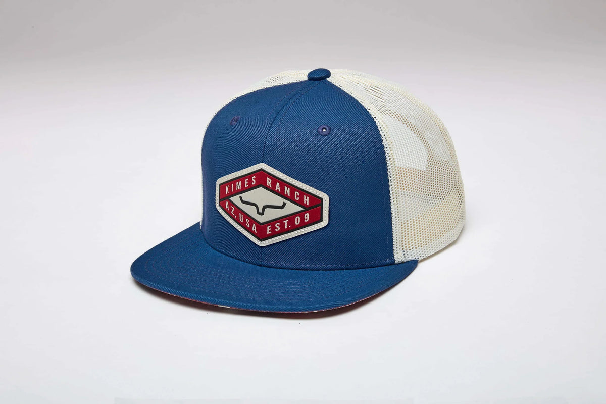 Kimes Ranch Boxer Trucker hat in Blue, side view, with a white mesh back and a red and white logo patch on the front