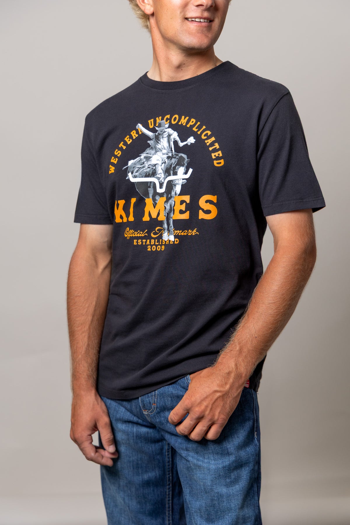 Kimes Ranch Break Through shirt in Black with a cowboy riding a steer graphic and Western Uncomplicated text