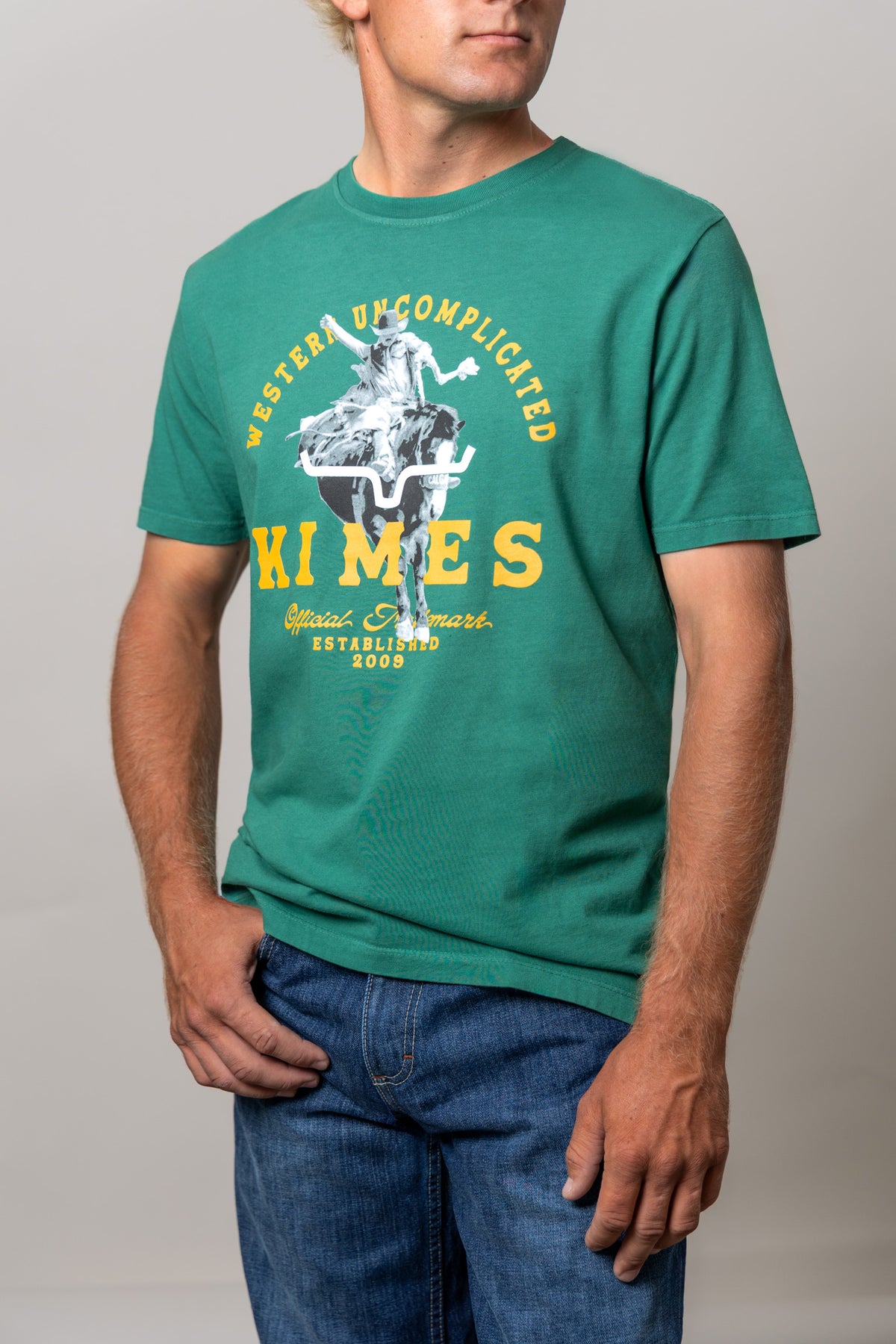 Kimes Ranch Break Through shirt in Green with a graphic of a cowboy riding a steer with Western Uncomplicated text