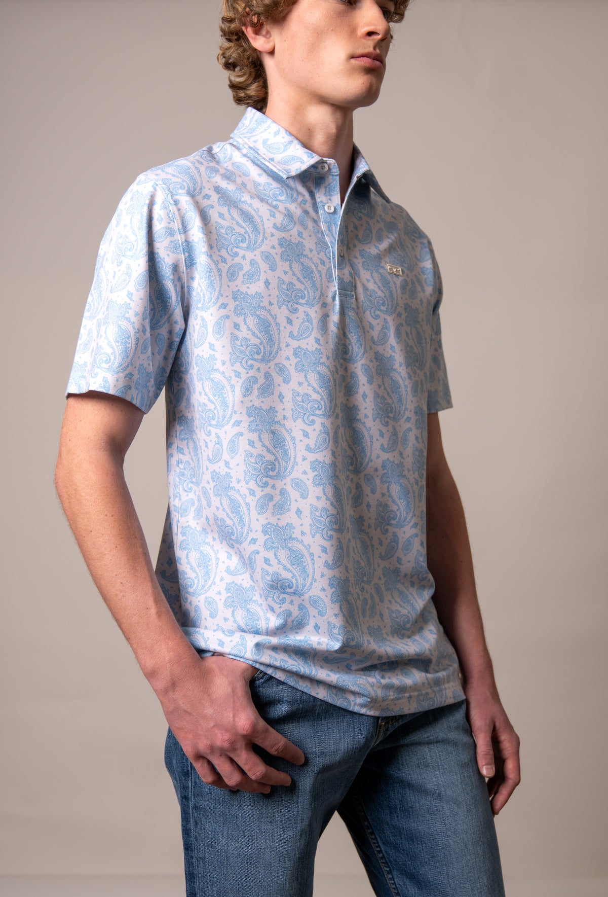 Kimes Ranch Burel polo shirt in Blue, side view, with a paisley pattern and a logo on the chest