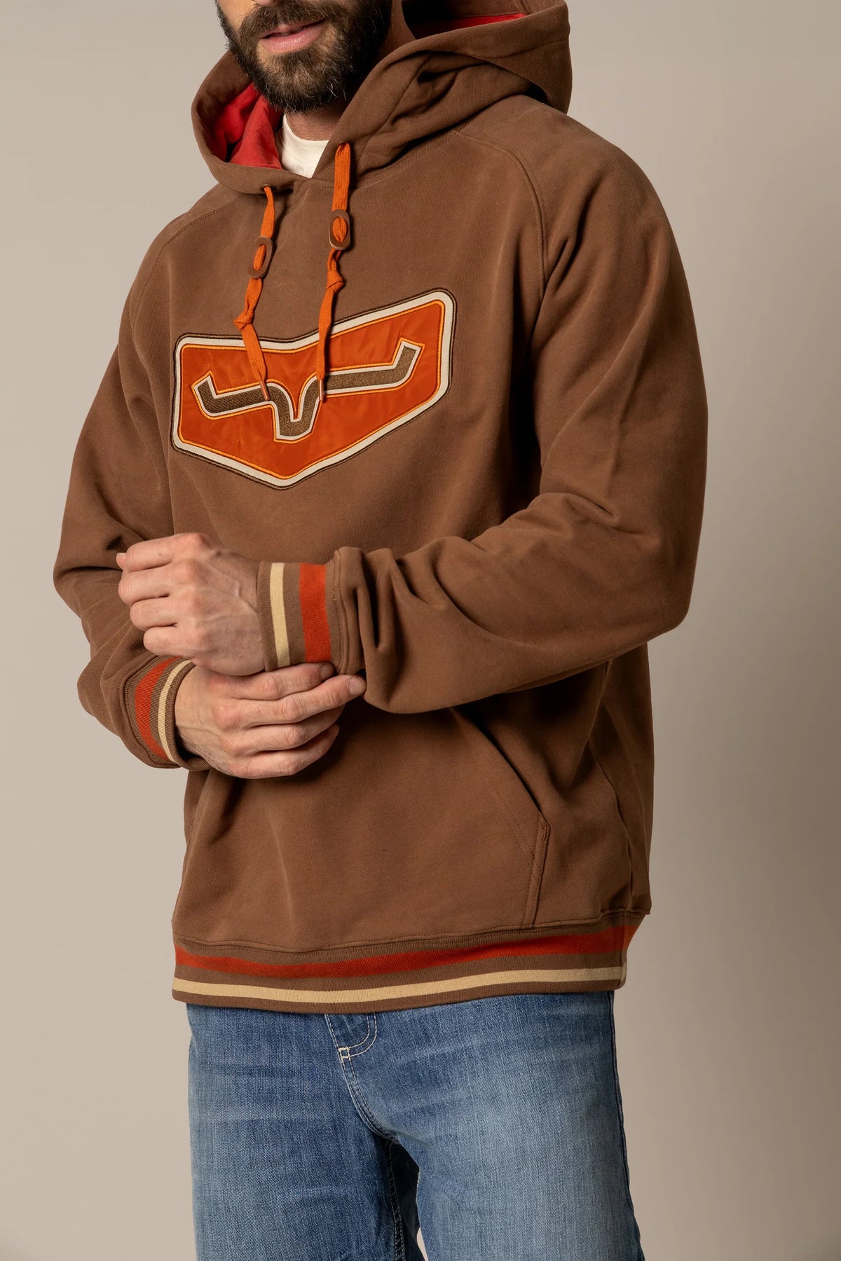 Kimes Ranch Cannons Hoodie in Brown with a large orange and white graphic on the chest and striped cuffs