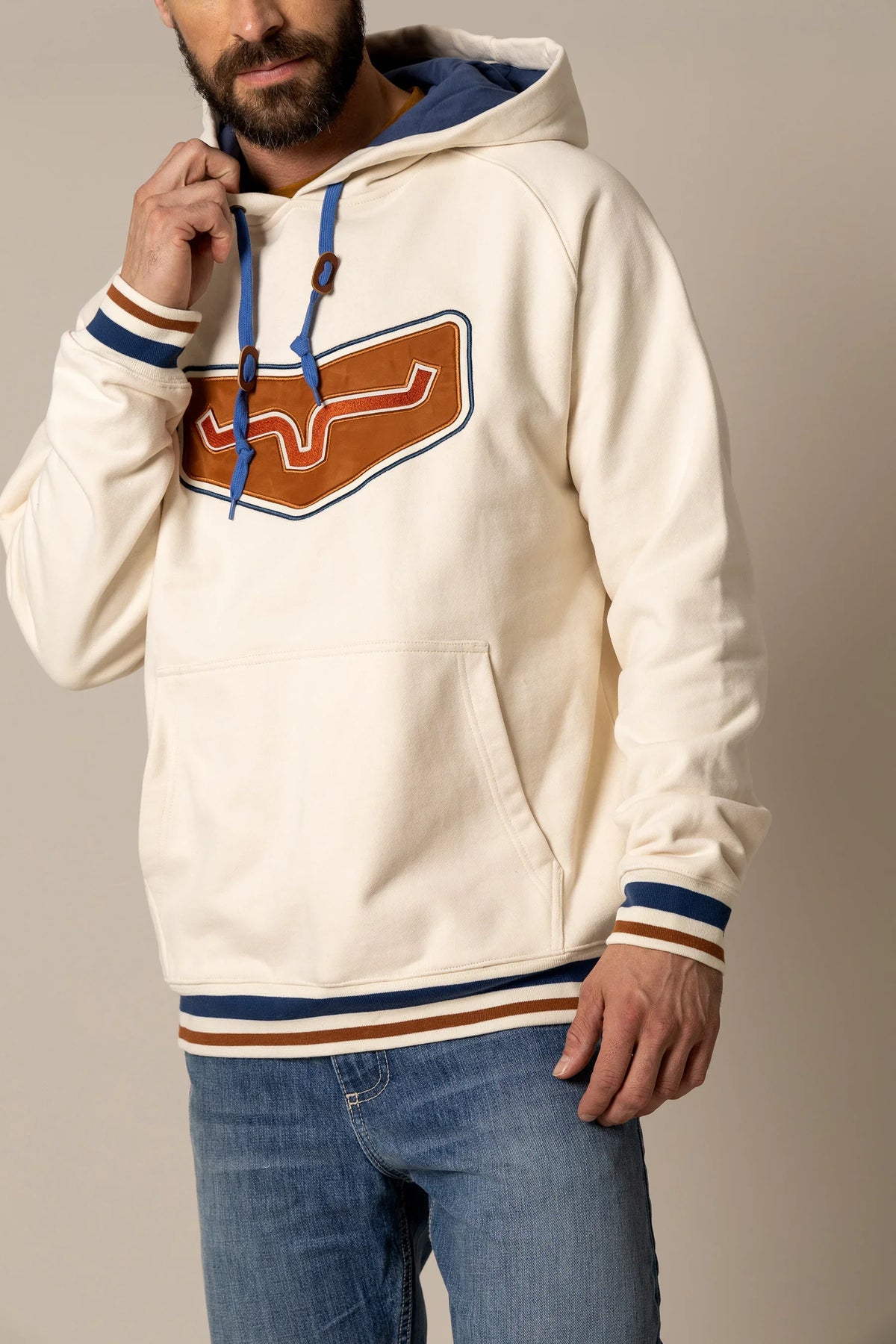 Kimes Ranch Cannons Hoodie in Natural with a large brown and blue graphic on the chest and striped cuffs
