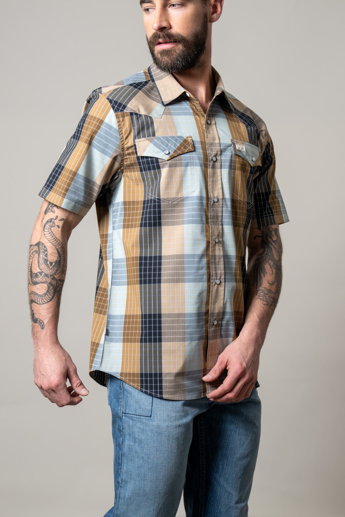 Kimes Ranch Chico short sleeve dress shirt in Brown with blue and tan plaid pattern and two chest pockets with button flaps