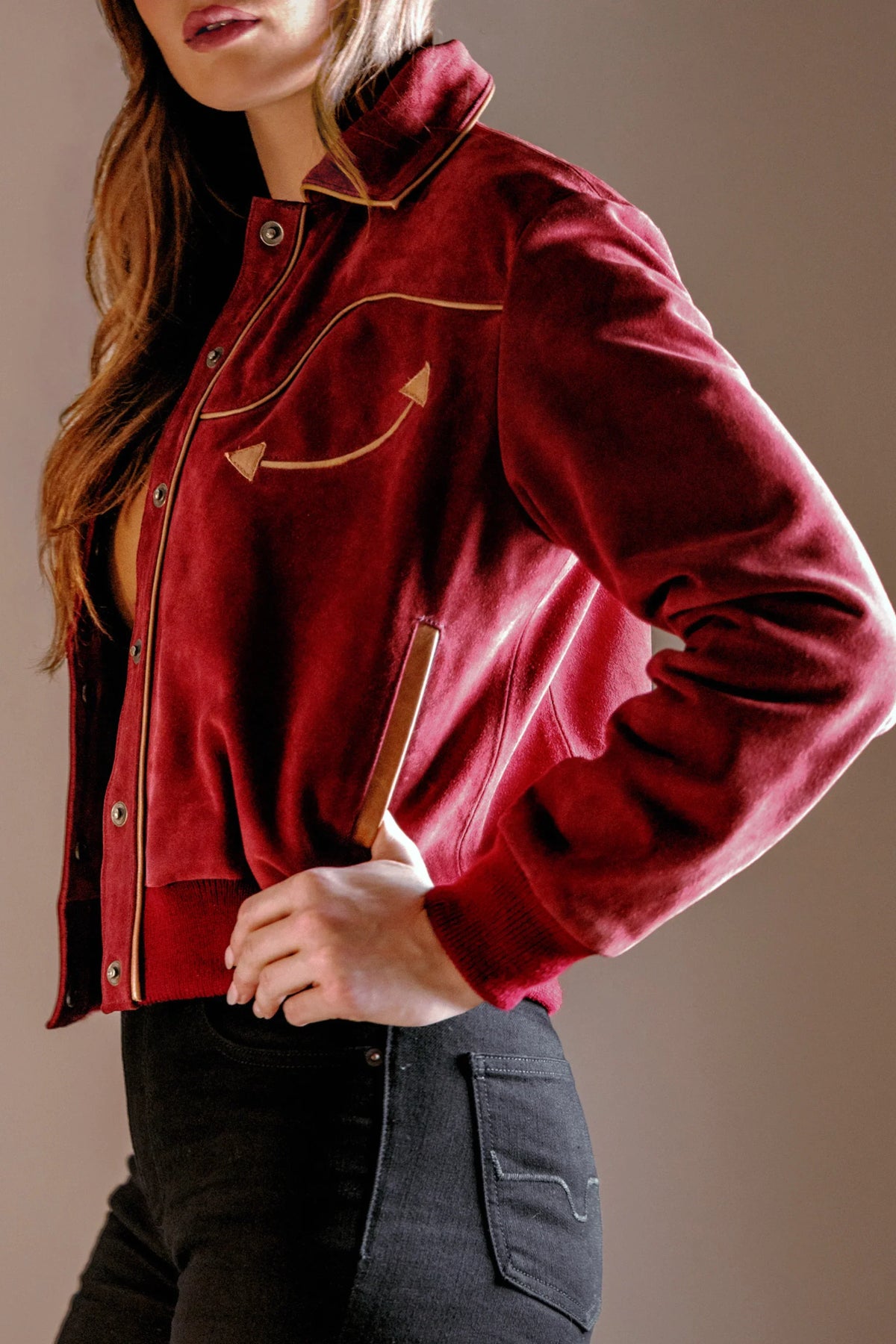 Kimes Ranch KR x Western & Co. Bomber Jacket, side view, in red with gold piping and a curved arrow graphic on the chest