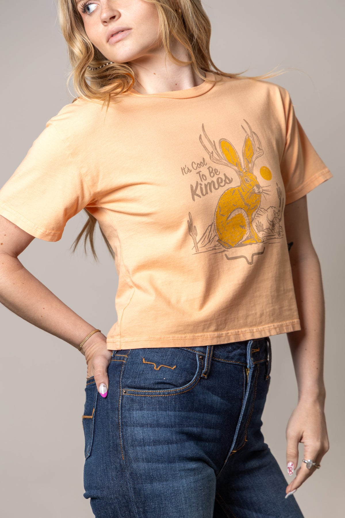 Kimes Ranch Cool Jack shirt in Peach with a graphic of a jackrabbit with antlers and the text It's Cool To Be Kimes