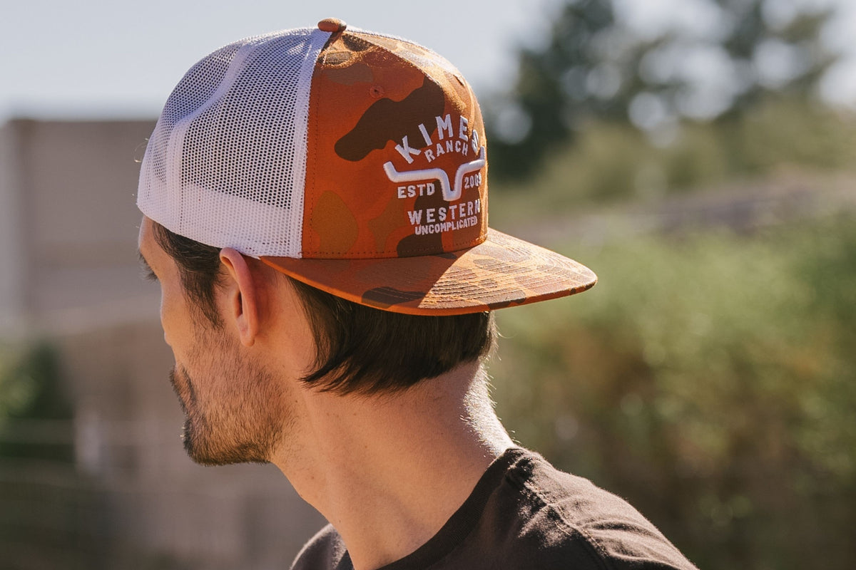 Kimes Ranch Grandview Trucker hat in Orange, side view, with white mesh back and logo print