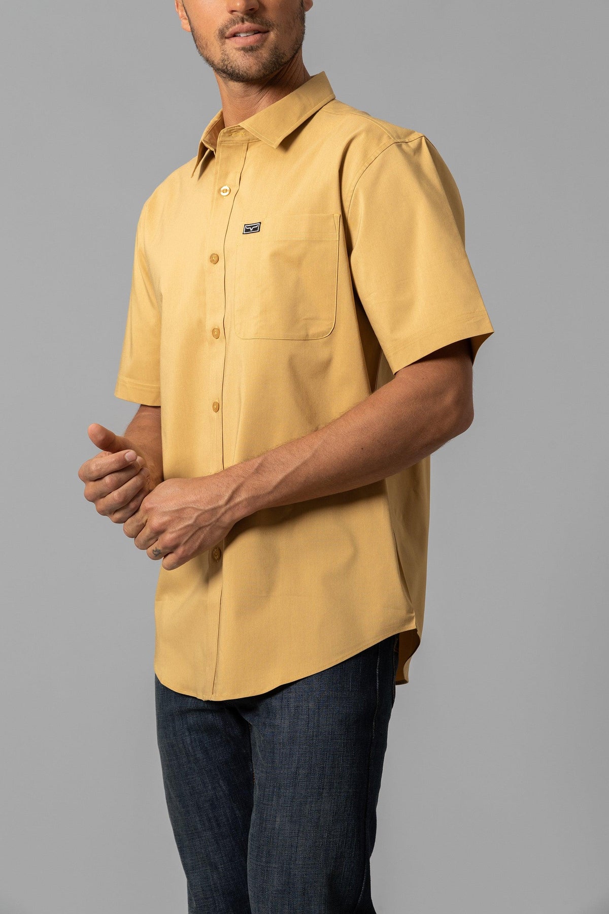 Kimes Ranch Linville Short Sleeve Dress Shirt in Gold, side view, with a chest pocket and logo patch
