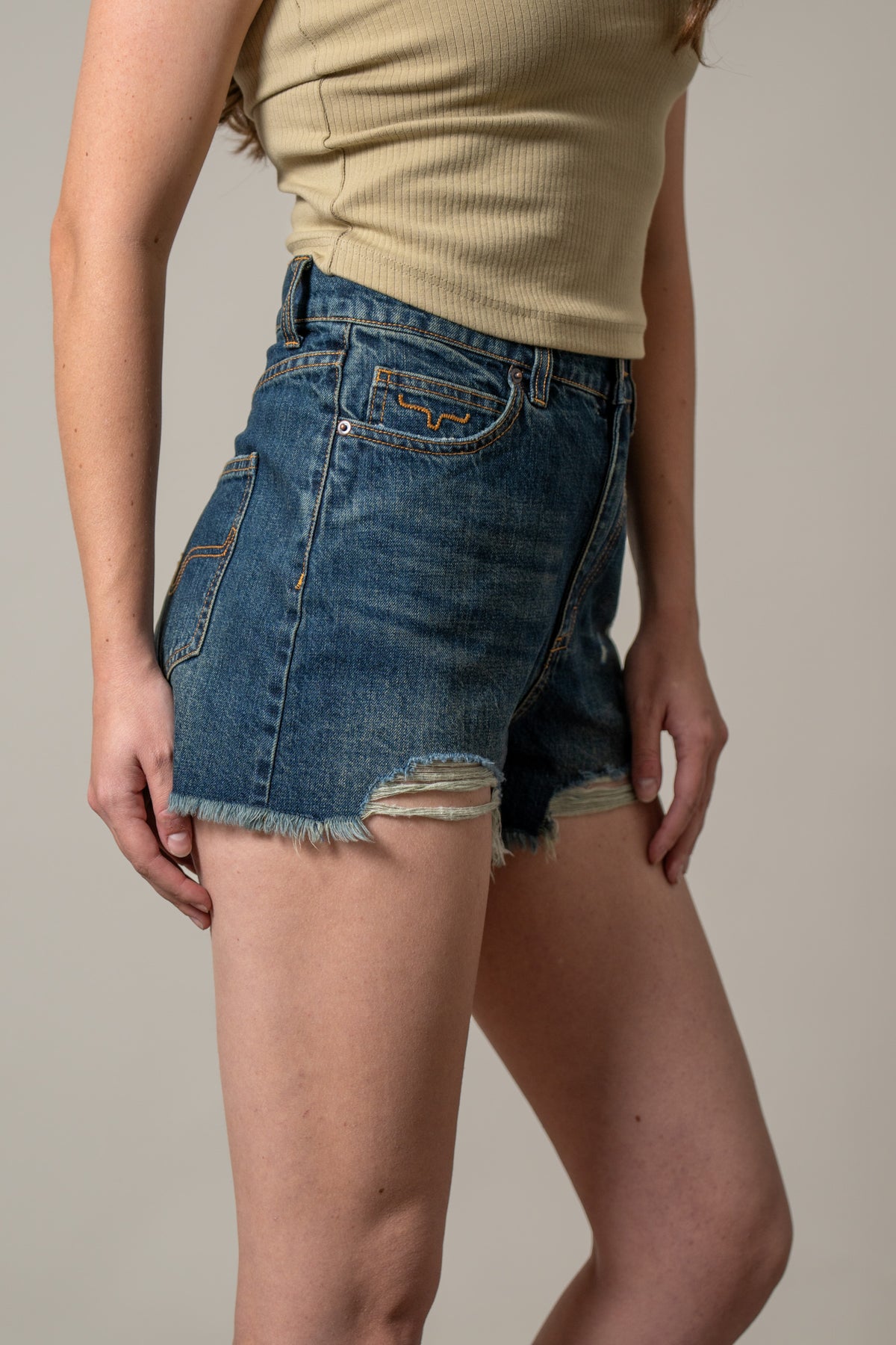 Kimes Ranch Daisy, side view, Dark Wash jeans with a frayed hem and front pockets