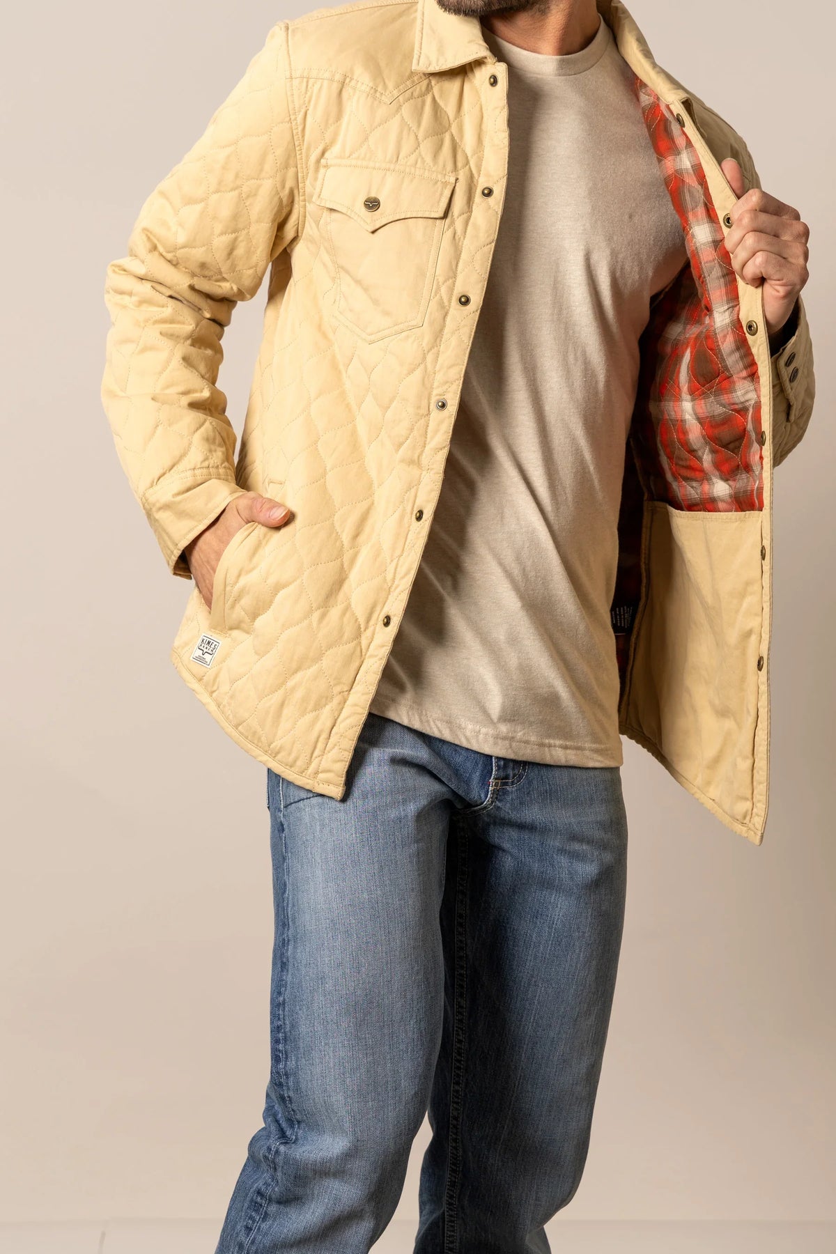 Kimes Ranch Dickson Shacket in Tan with diamond quilting, front pockets, and red plaid lining