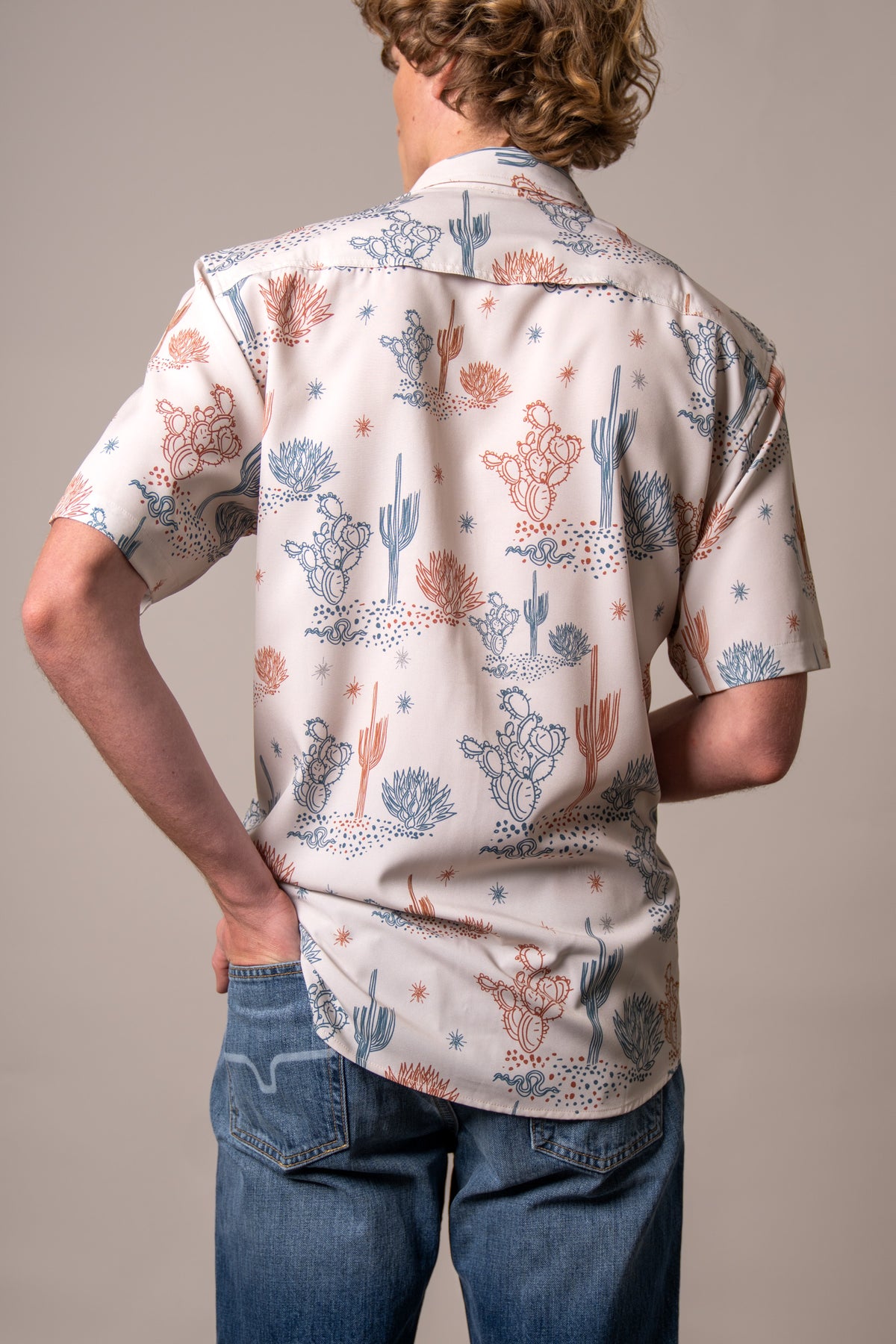 Kimes Ranch Dunn dress shirt in Natural, back view, with a desert print of cacti and stars in blue and orange