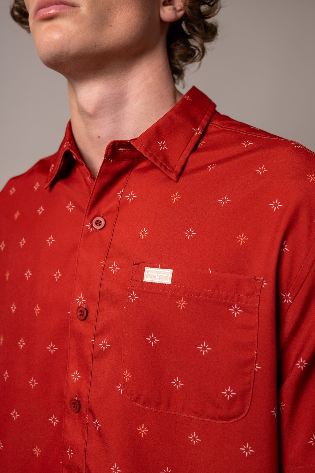 Kimes Ranch Dunn dress shirt in Red, close-up, with a star pattern and a chest pocket with a logo patch