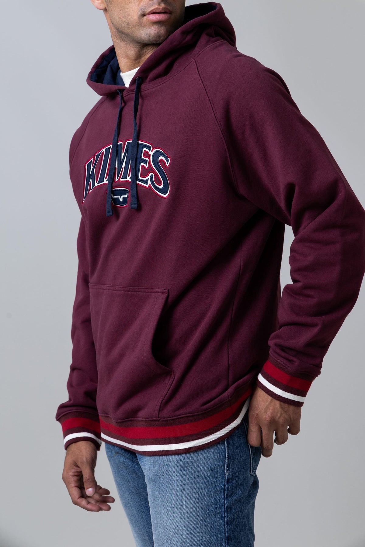Kimes Ranch Kubo Hoodie in Burgundy, side view, with front kangaroo pocket and striped ribbed cuffs