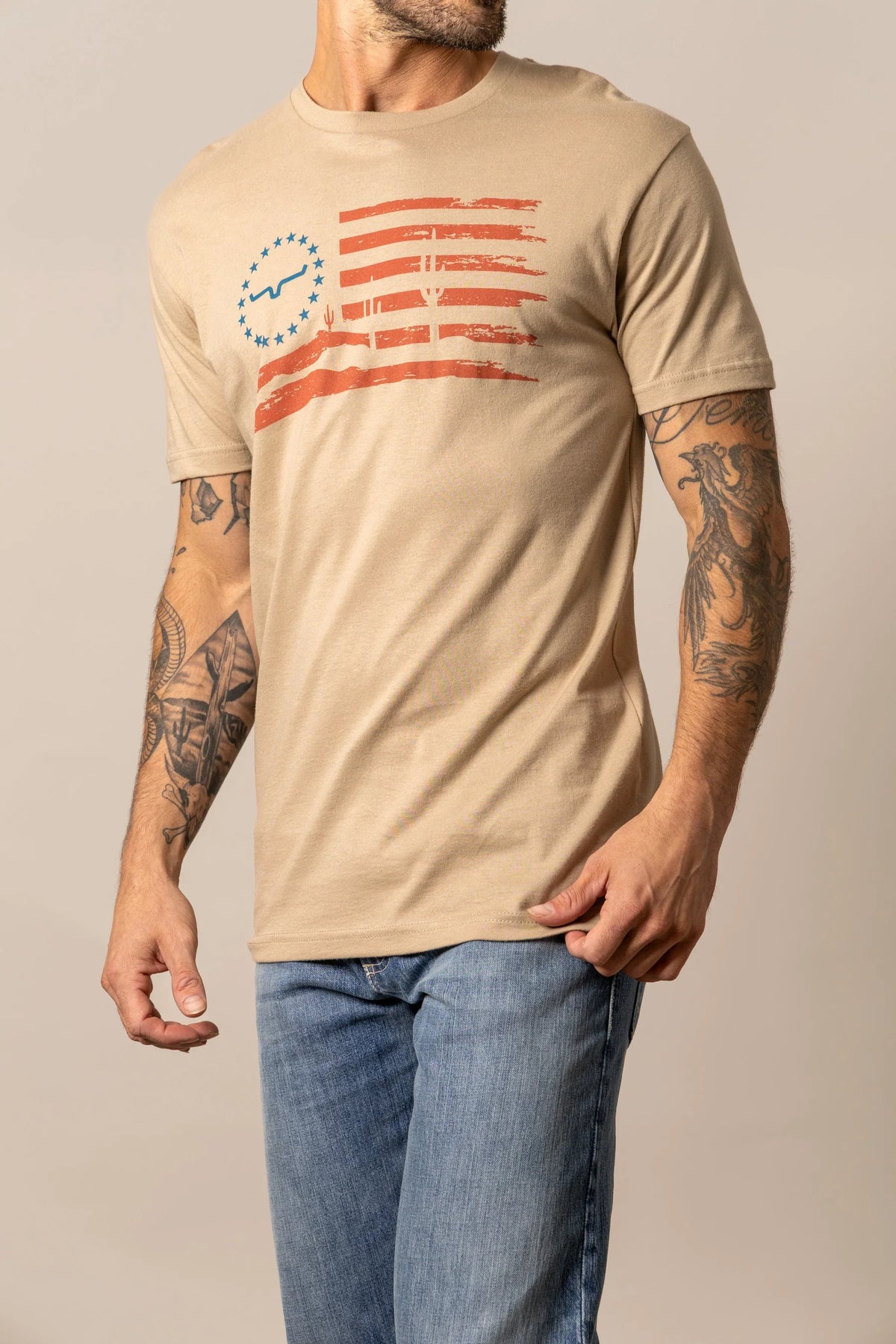Kimes Ranch Faded Tan short sleeve shirt with a distressed flag graphic featuring blue stars and orange stripes