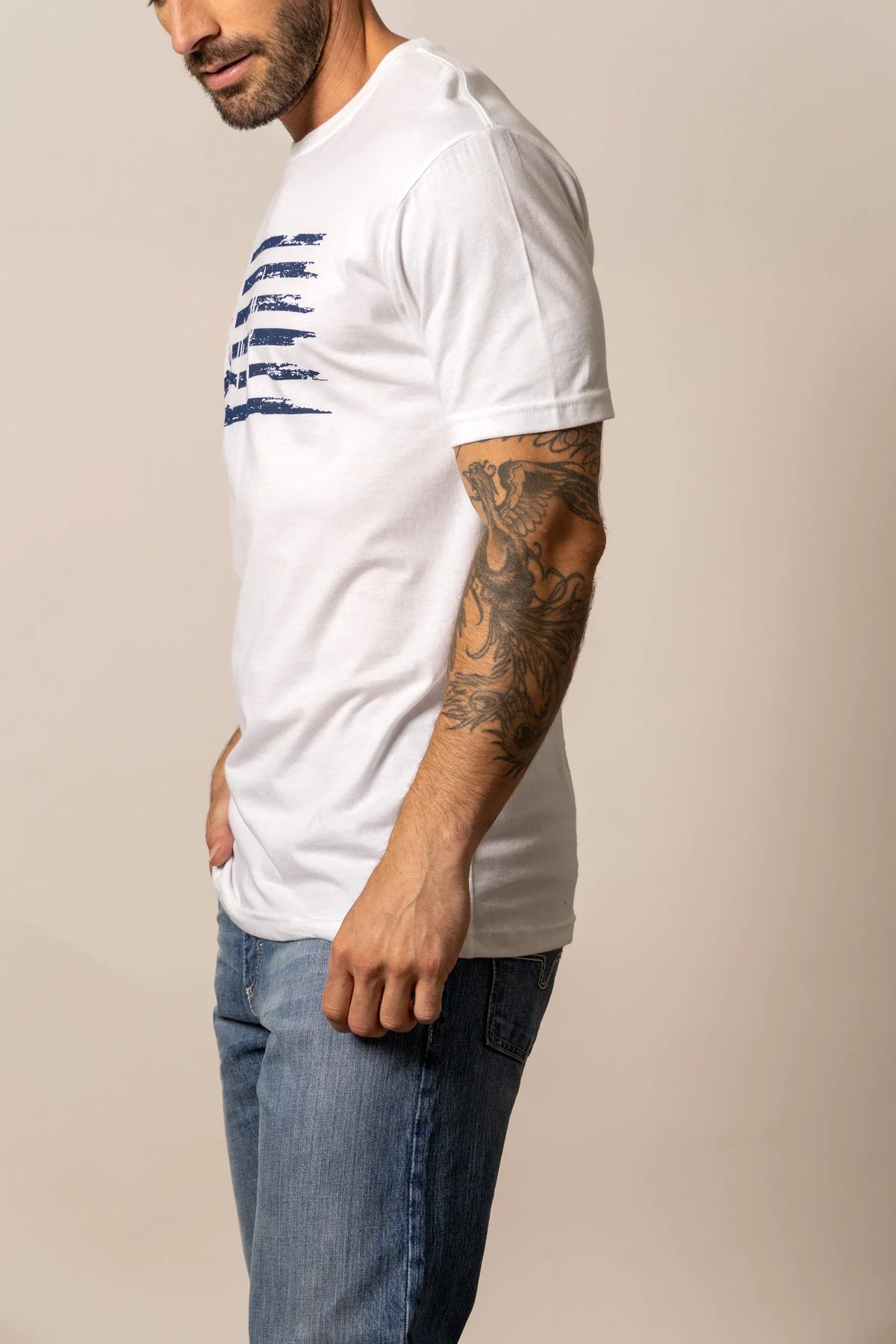 Kimes Ranch Faded, side view, White short sleeve shirt with a distressed navy flag graphic on the chest