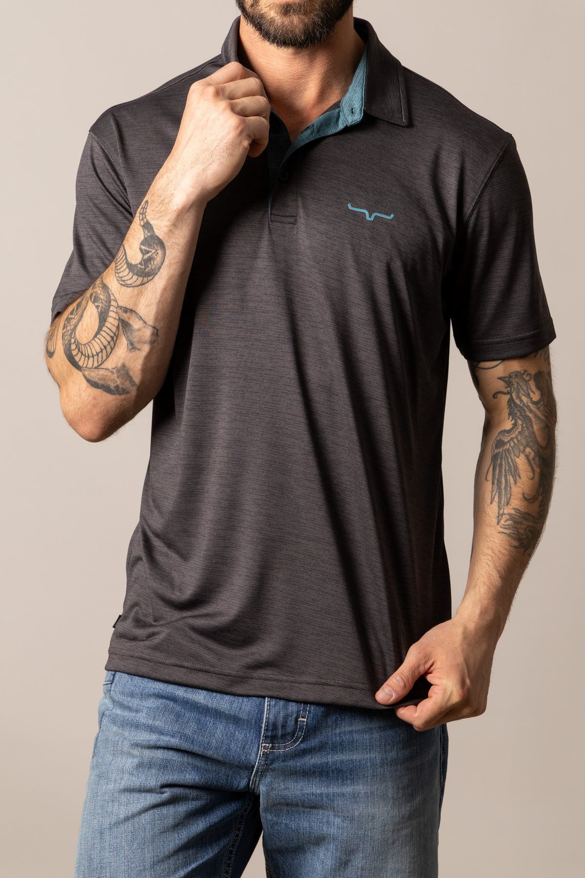 Kimes Ranch Fletcher polo in Black with a contrasting teal inner collar and a small blue logo on the chest