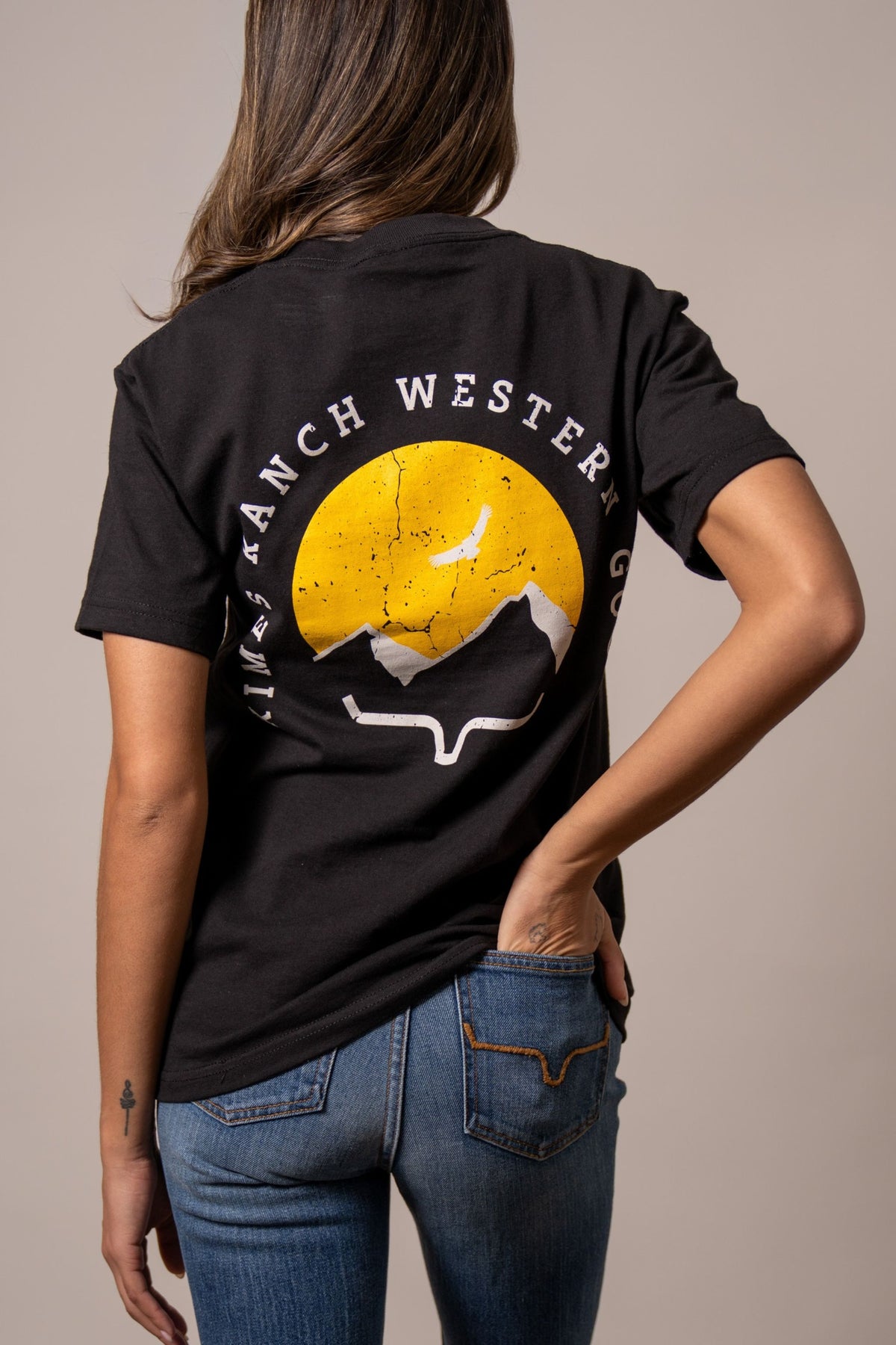 Kimes Ranch Flying High, back view, shirt back with yellow sun graphic and white mountains with the text KIMES RANCH WESTERN