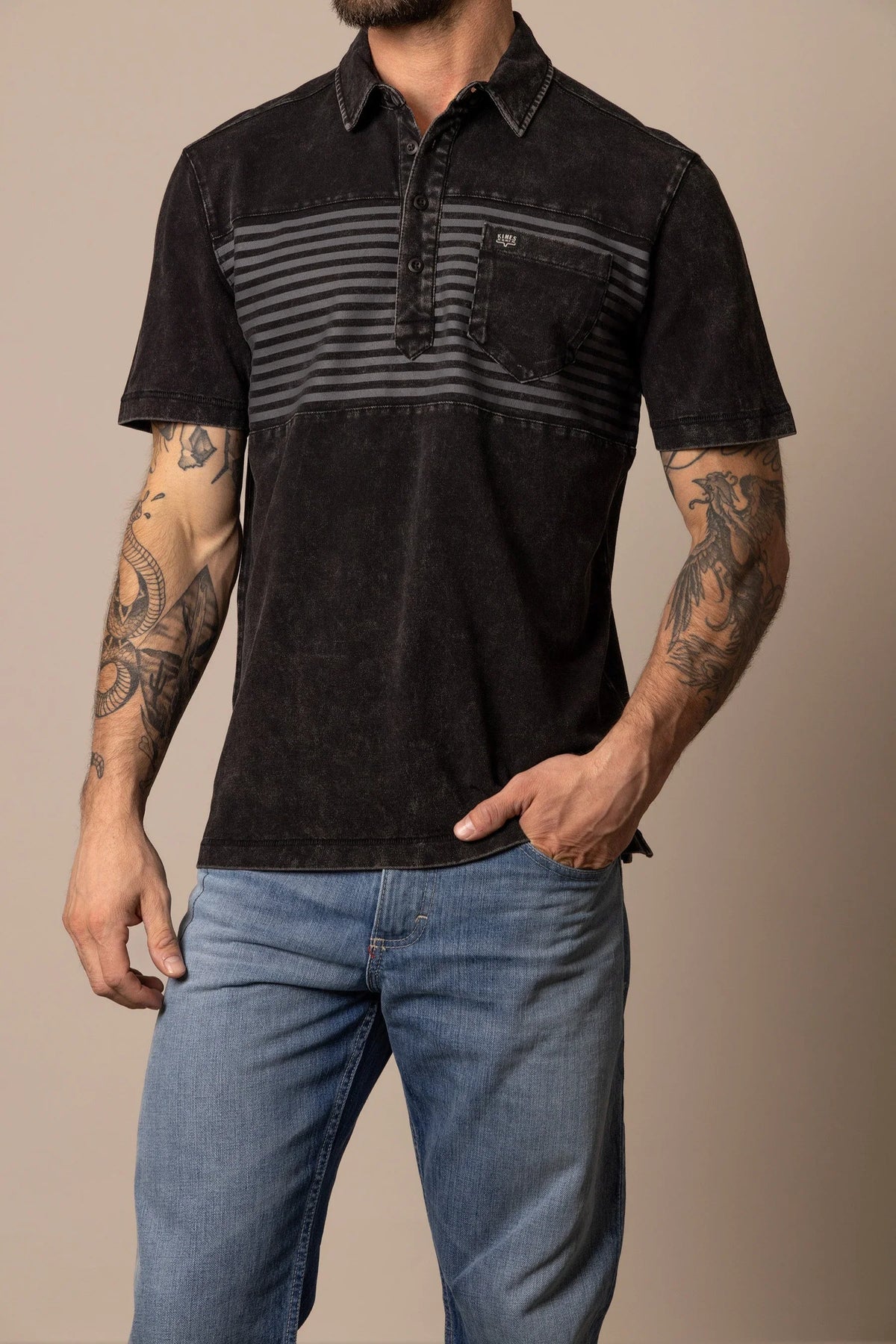 Kimes Ranch Holbrook Polo in Black with a striped chest panel and a chest pocket with the Kimes Ranch logo