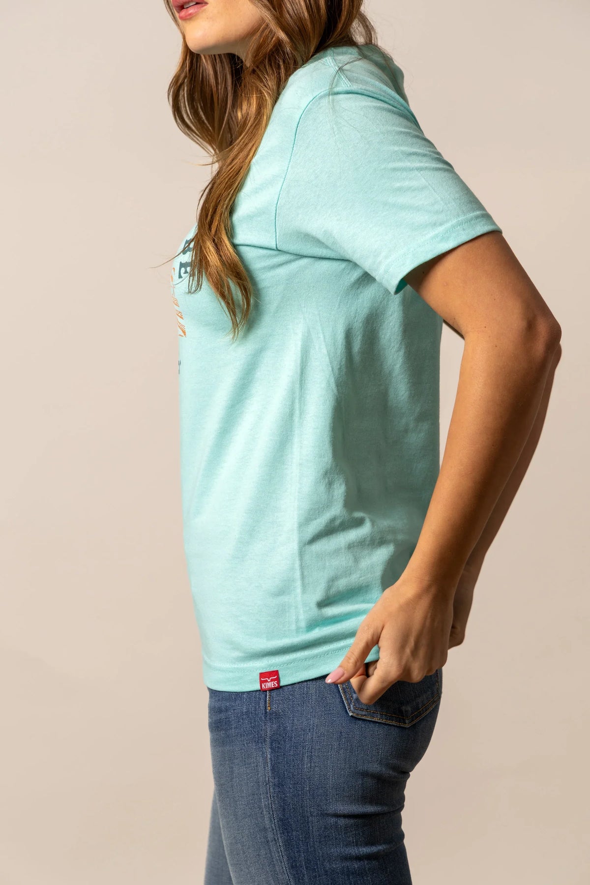 Kimes Ranch It's Cool to be Kimes shirt in Light Blue, side view, with short sleeves and a red logo tag at the hem