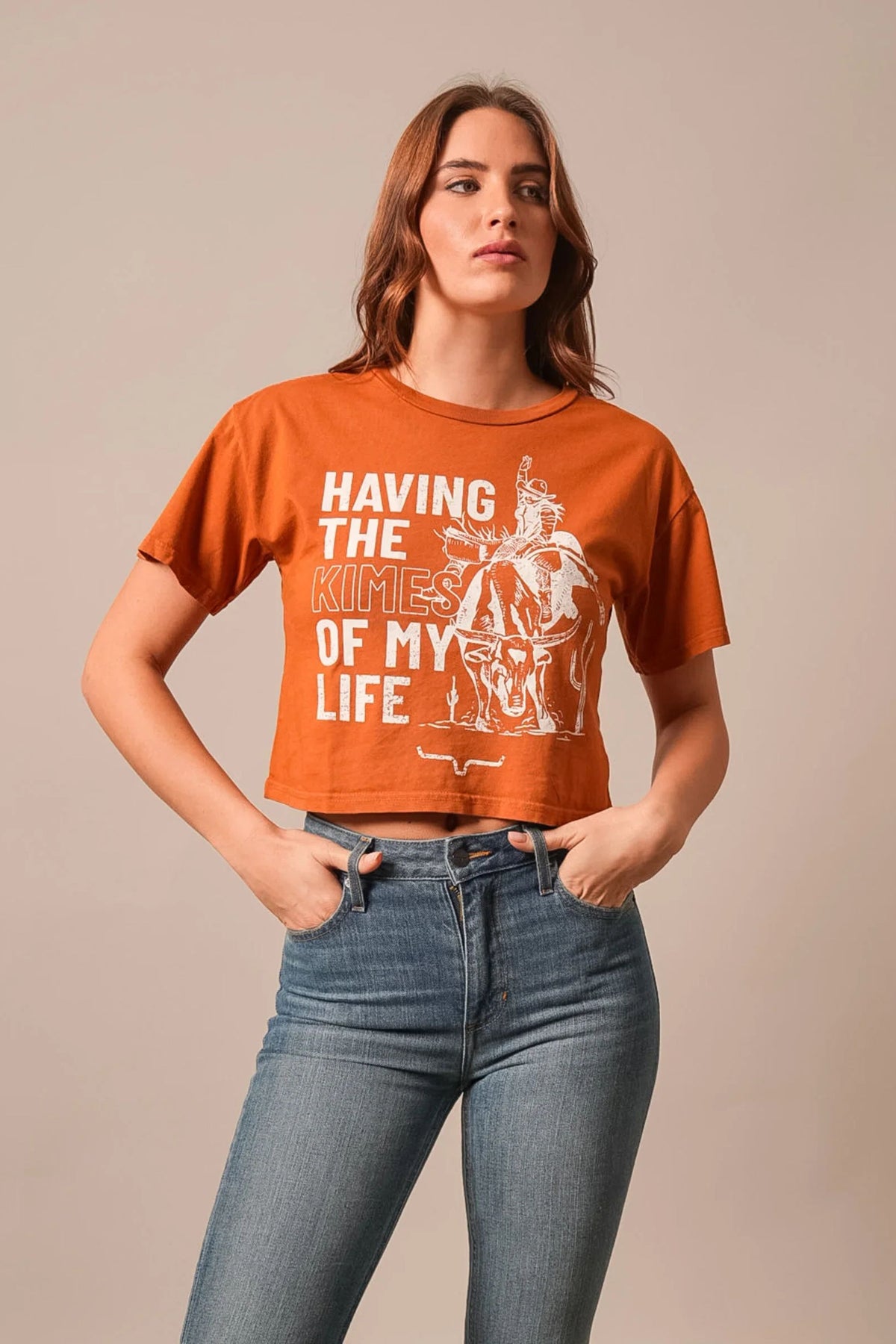 Kimes Ranch Kimes Of My Life shirt in Rust with a graphic of a cowboy on a steer and the text Having The Kimes Of My Life