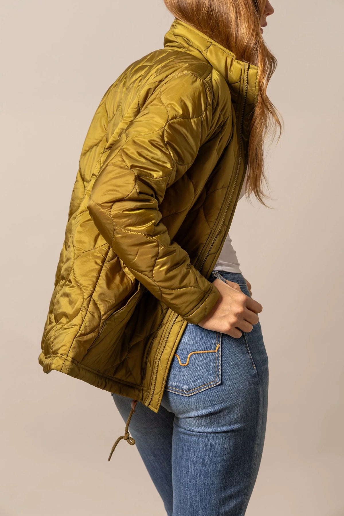 Kimes Ranch Lara Jacket in Olive, side view, with a diamond quilted pattern and a drawstring hem