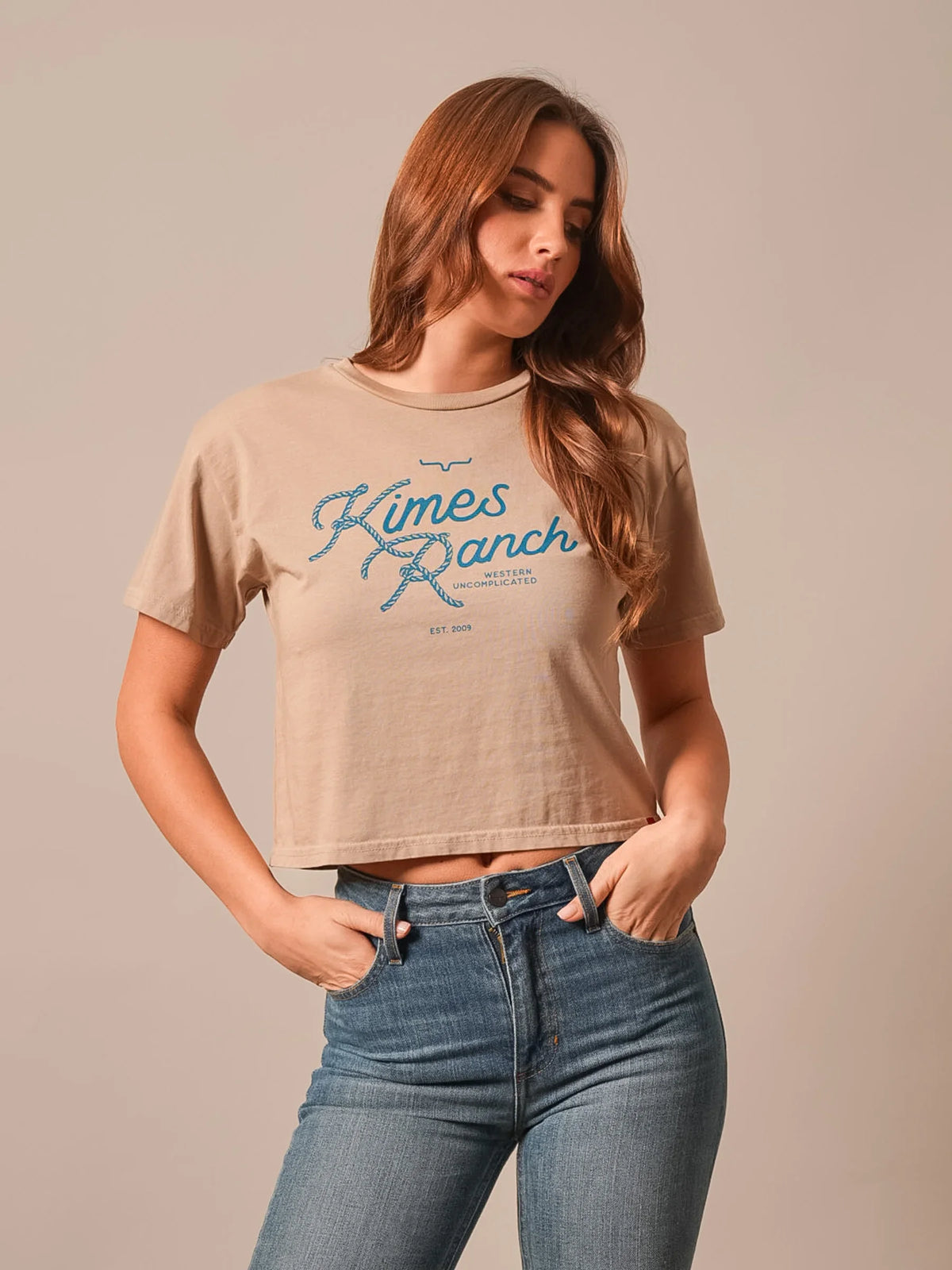 Kimes Ranch Lasso Script Tan short sleeve shirt with blue rope script logo and Western Uncomplicated text