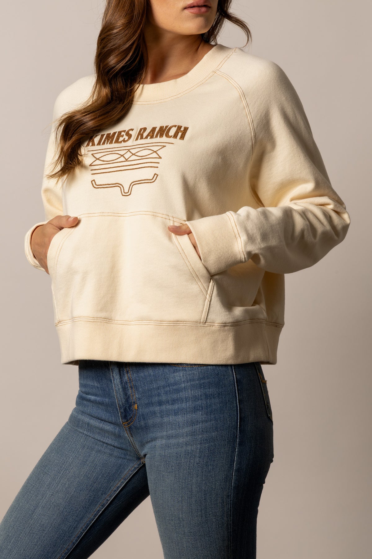 Kimes Ranch Lexie sweatshirt in Butter with a front kangaroo pocket and a Kimes Ranch logo graphic
