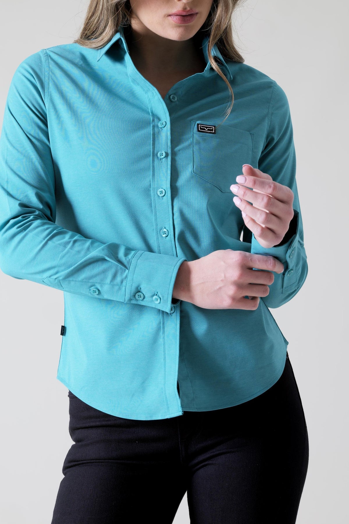 Kimes Ranch Ladies Linville top in Teal with a button front, chest pocket with logo, and long sleeves