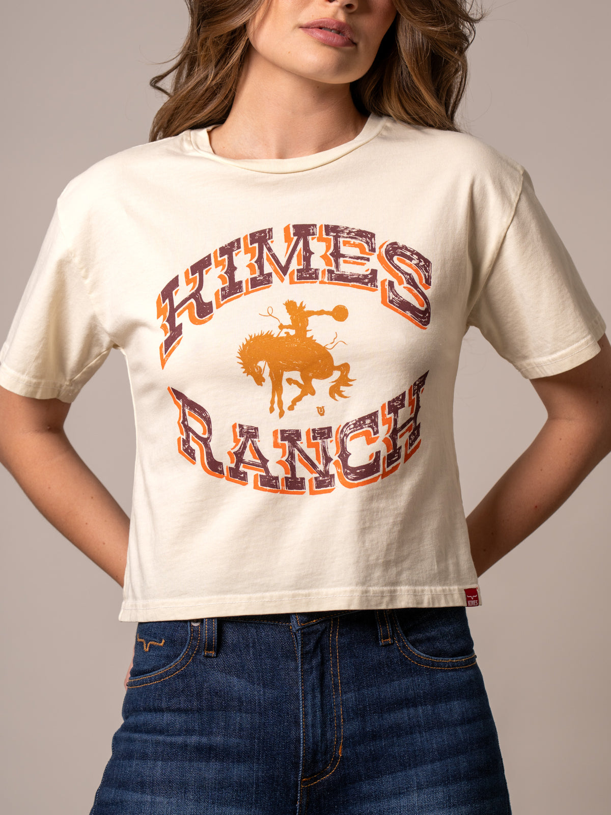 Kimes Ranch Lucky B Bucking shirt in Ivory with a graphic of a cowboy riding a bucking horse and the words Kimes Ranch