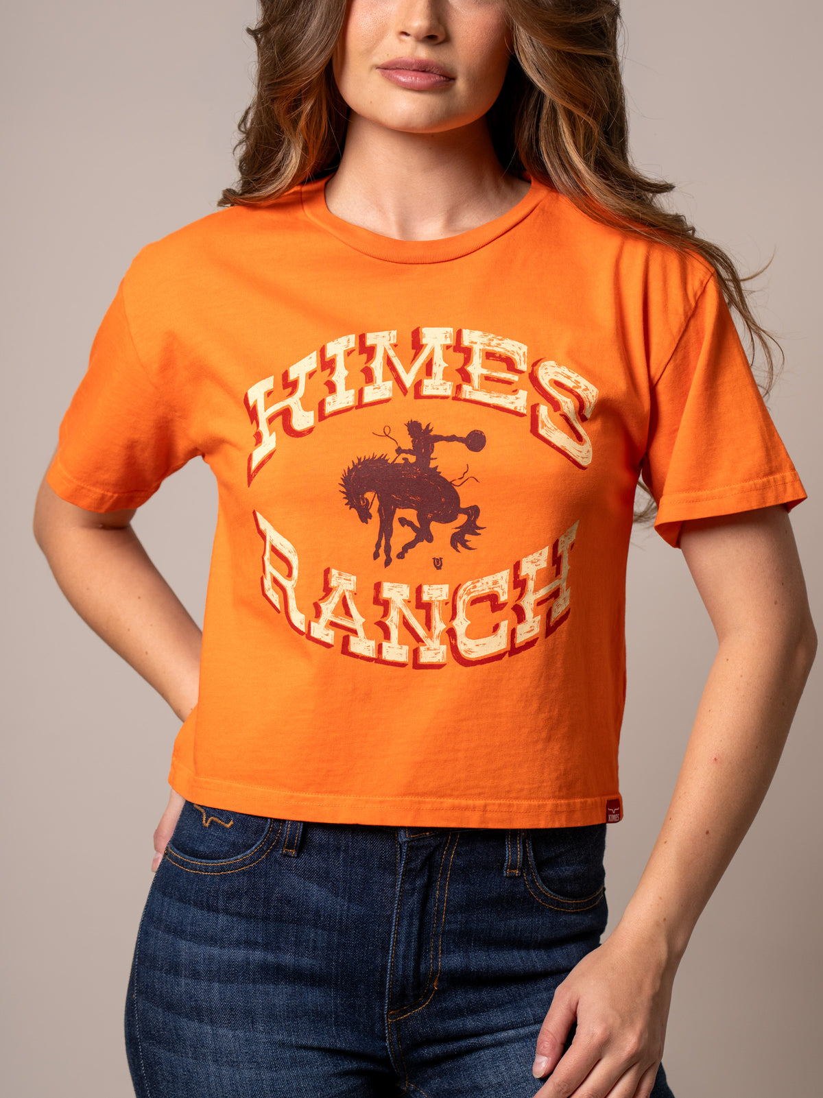 Kimes Ranch Lucky B Bucking shirt in Vintage Orange with a graphic of a cowboy on a bucking horse