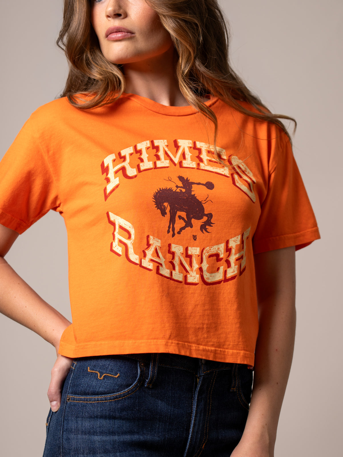 Kimes Ranch Lucky B Bucking shirt in Vintage Orange with a graphic of a cowboy on a bucking horse and the brand name