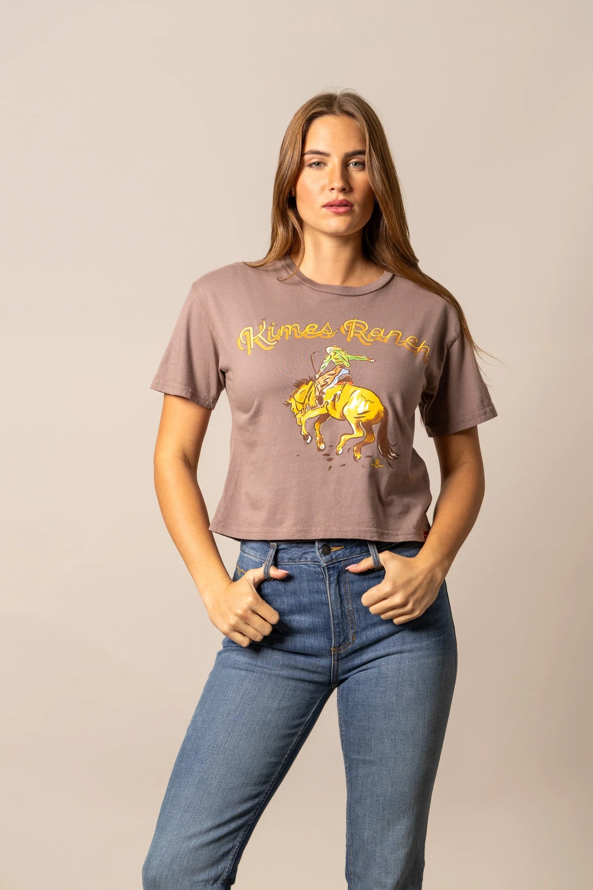 Kimes Ranch Lucky B Rodee-oh! shirt in Mocha with a graphic of a cowboy riding a bucking horse and the Kimes Ranch logo
