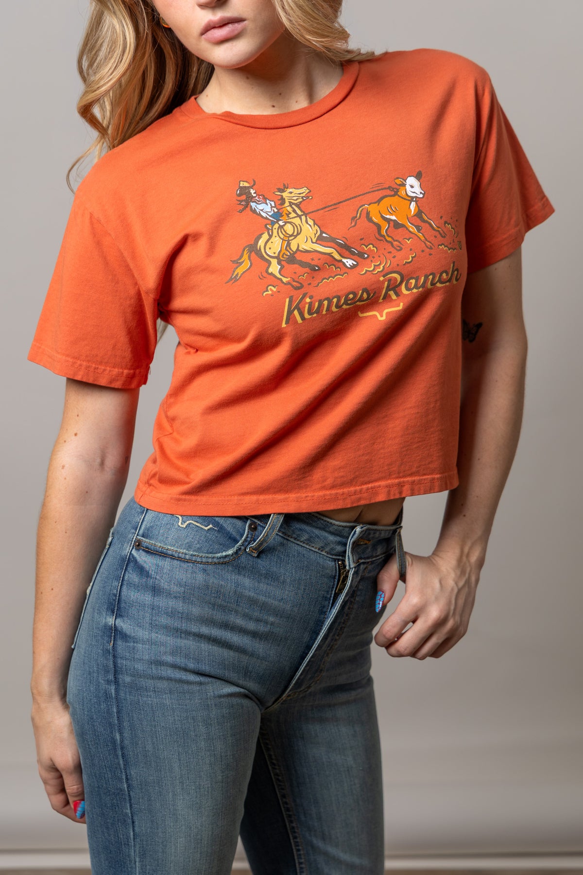 Kimes Ranch Lucky B Roper Spice Red short sleeve shirt with a graphic of a rodeo rider roping a calf and the Kimes Ranch logo