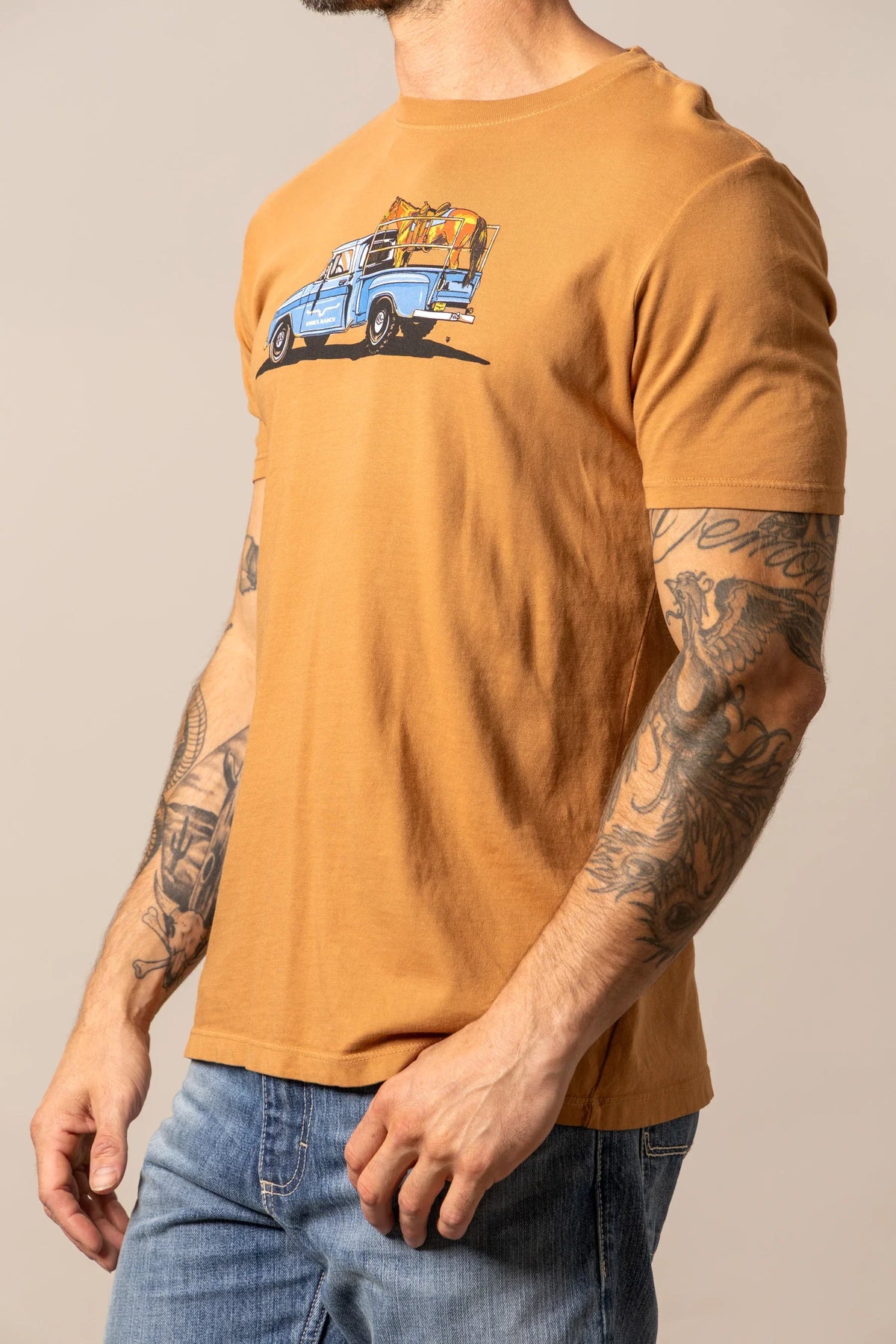 Kimes Ranch Lucky B Truck shirt in Work Wear Brown, side view, with a graphic of a blue truck carrying horses