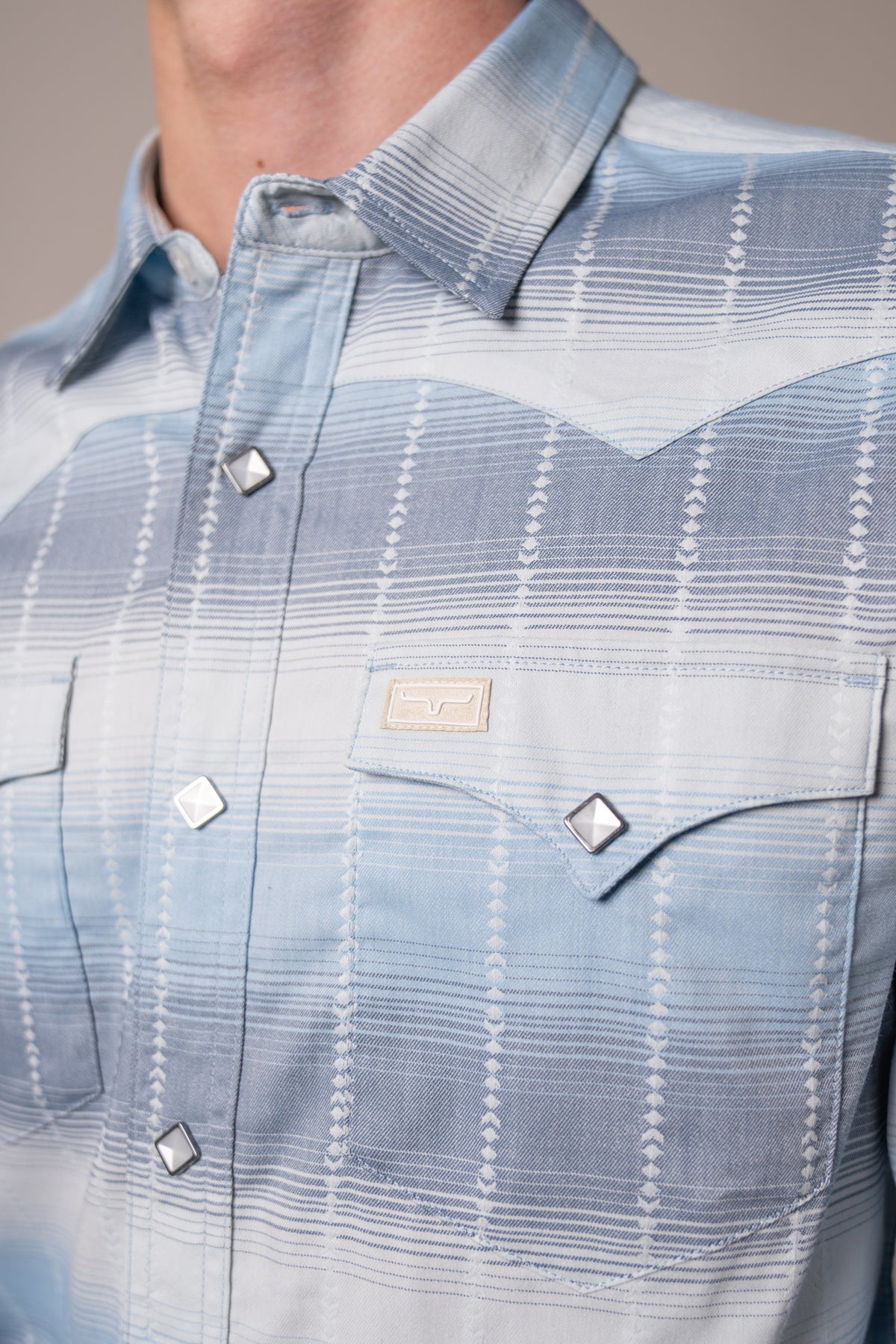 Kimes Ranch Lyle dress shirt in Blue with a close-up of the collar, yoke, and front pockets with silver buttons